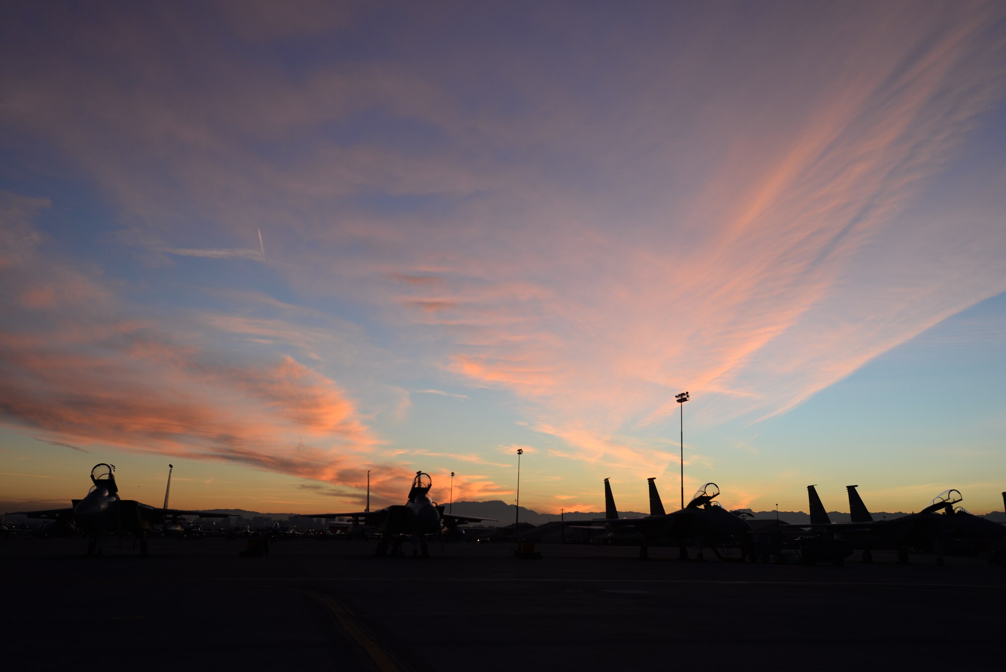 Four F-15C Eagles assigned to the 493rd Fighter Squadron, Royal Air Force Lakenheath, England, sit on the flightline at dusk during Red Flag 15-1 at Nellis Air Force Base, Nev., Feb. 2, 2015. Red Flag is a realistic combat exercise involving U.S. and allied air forces conducting training operations on the 15,000 square mile Nevada Test and Training Range. (U.S. Air Force photo by Tech. Sgt. Eric Burks/Released)