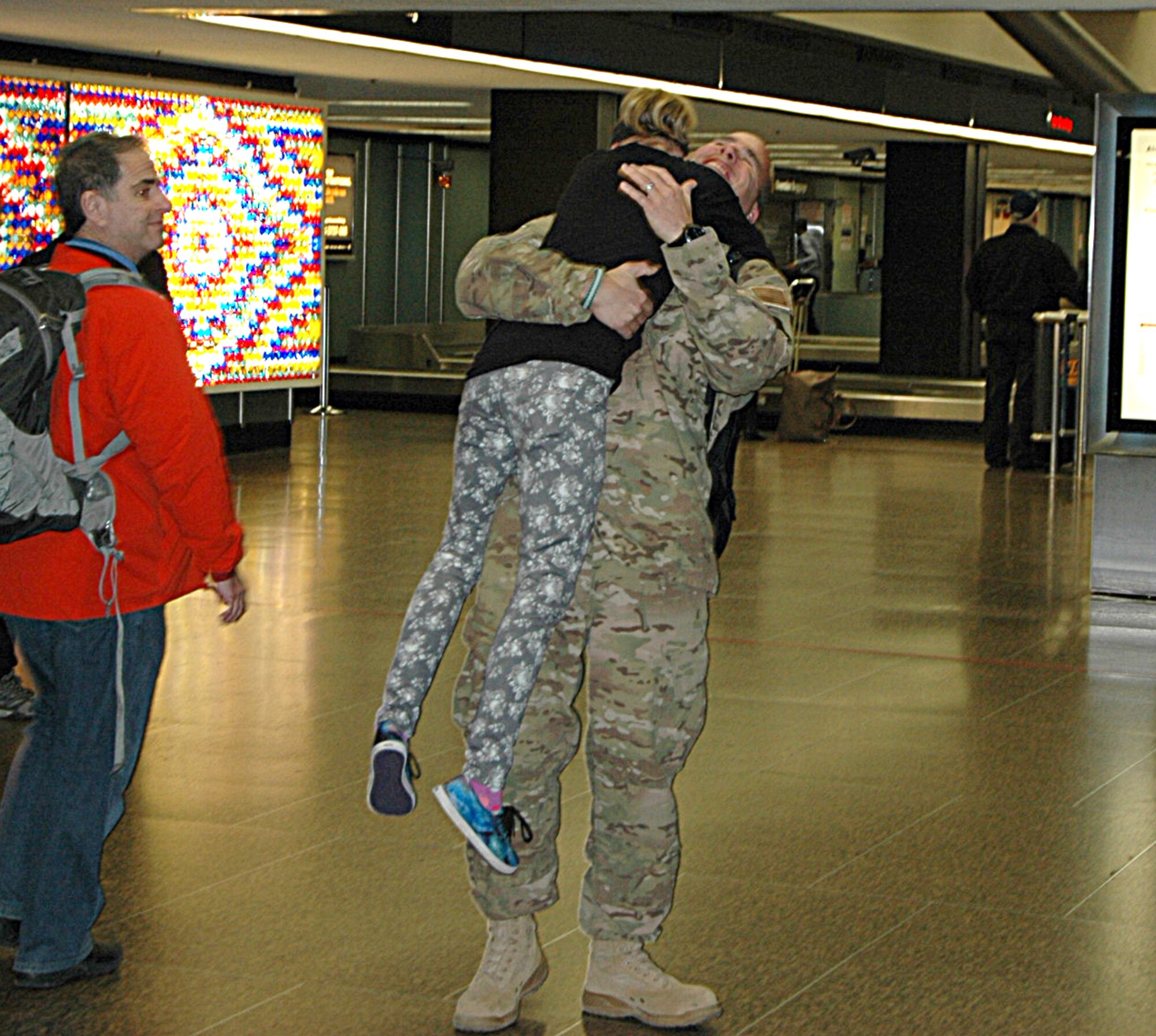 At the Seattle-Tacoma Airport Feb. 5, Hadley Abel, age 10, jumps into her dad's arms as he arrives home from a three-month deployment. Master. Sgt. Gregory Abel, 86th Aerial Port Squadron, Joint Base Lewis-McChord, Washington, was among eight Citizen Airmen returning from a deployment to Senegal in support of Operation United Assistance. (U.S. Air Force Reserve photo by Sandra Pishner)