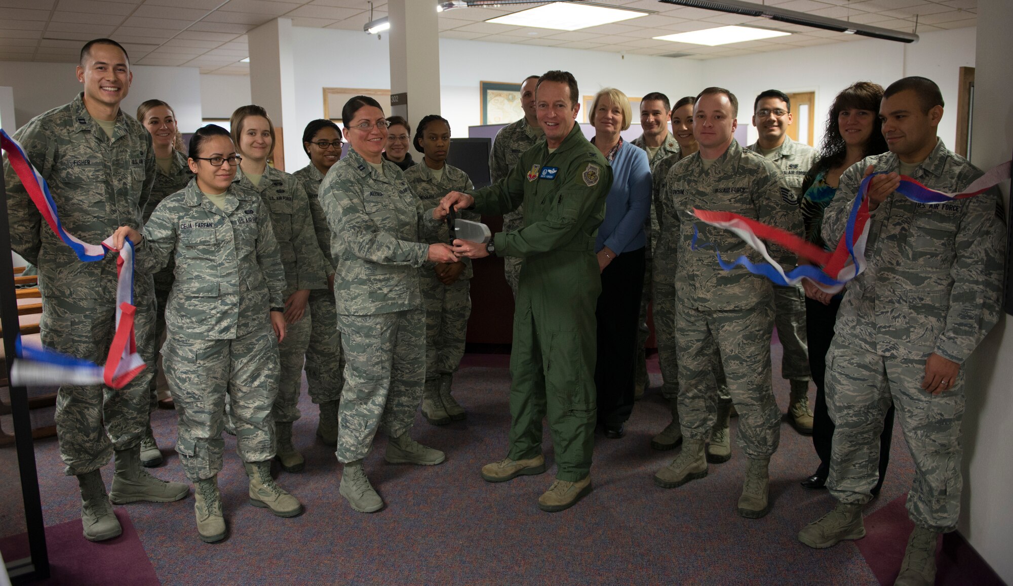 Col. David Iverson (center-right), 366th Fighter Wing commander, cuts a ceremonial ribbon with Capt. Chandra Alegria during the tax center grand opening Feb. 2, 2015, at Mountain Home Air Force Base, Idaho. (U.S. Air Force photo by Senior Airman Malissa Lott/RELEASED)