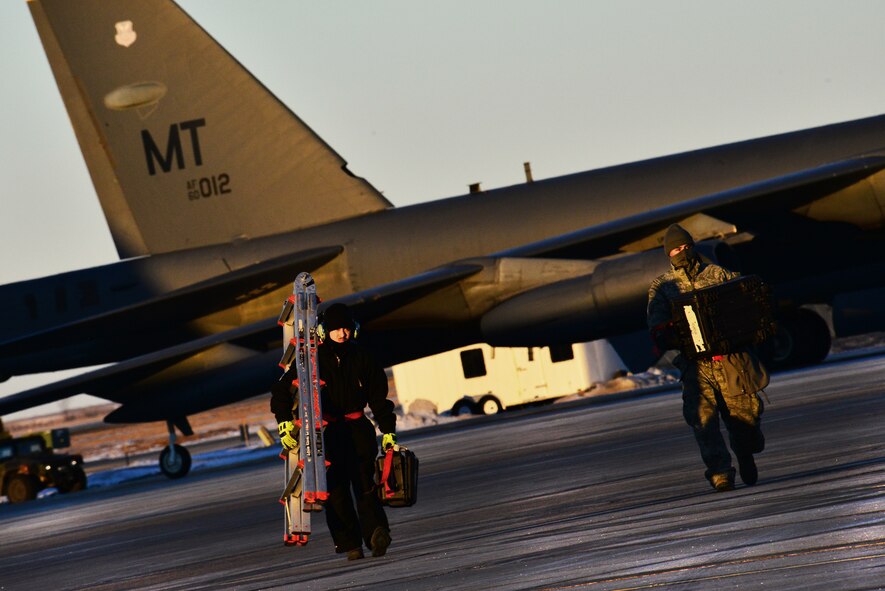 Airmen from the 5th Maintenance Group carry equipment on the flightline at Minot Air Force Base, N.D., Jan. 12, 2015. Aircraft maintenance Airmen provide maintenance and upkeep to the jets, even during the cold winter months. (U.S. Air Force photo/Senior Airman Brittany Y. Bateman)