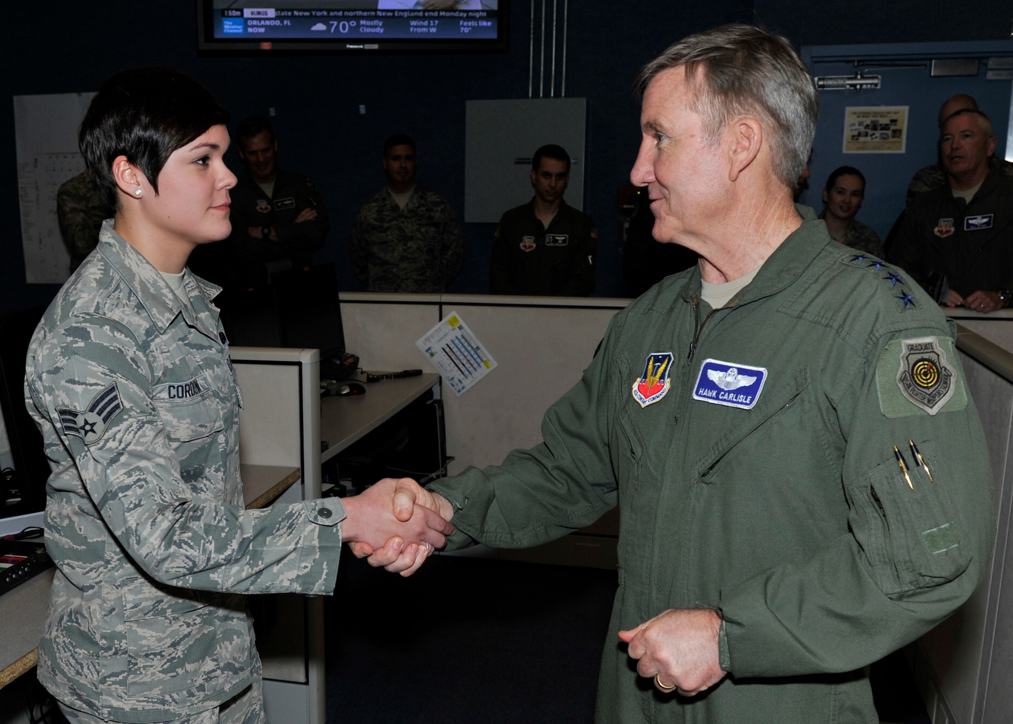 U. S. Air Force Gen. "Hawk" Carlisle, commander of Air Combat Command, presents his coin to Senior Airman Christina Cordova, 101st Air Communications Squadron, Feb. 2 at the 601st Air Operations Center, Tyndall Air Force Base, Fla. Cordova was not only recognized for her outstanding duty performance, but also for her volunteer activities in the local community. (U.S. Air Force photo by A1C Sergio Gamboa/Released)