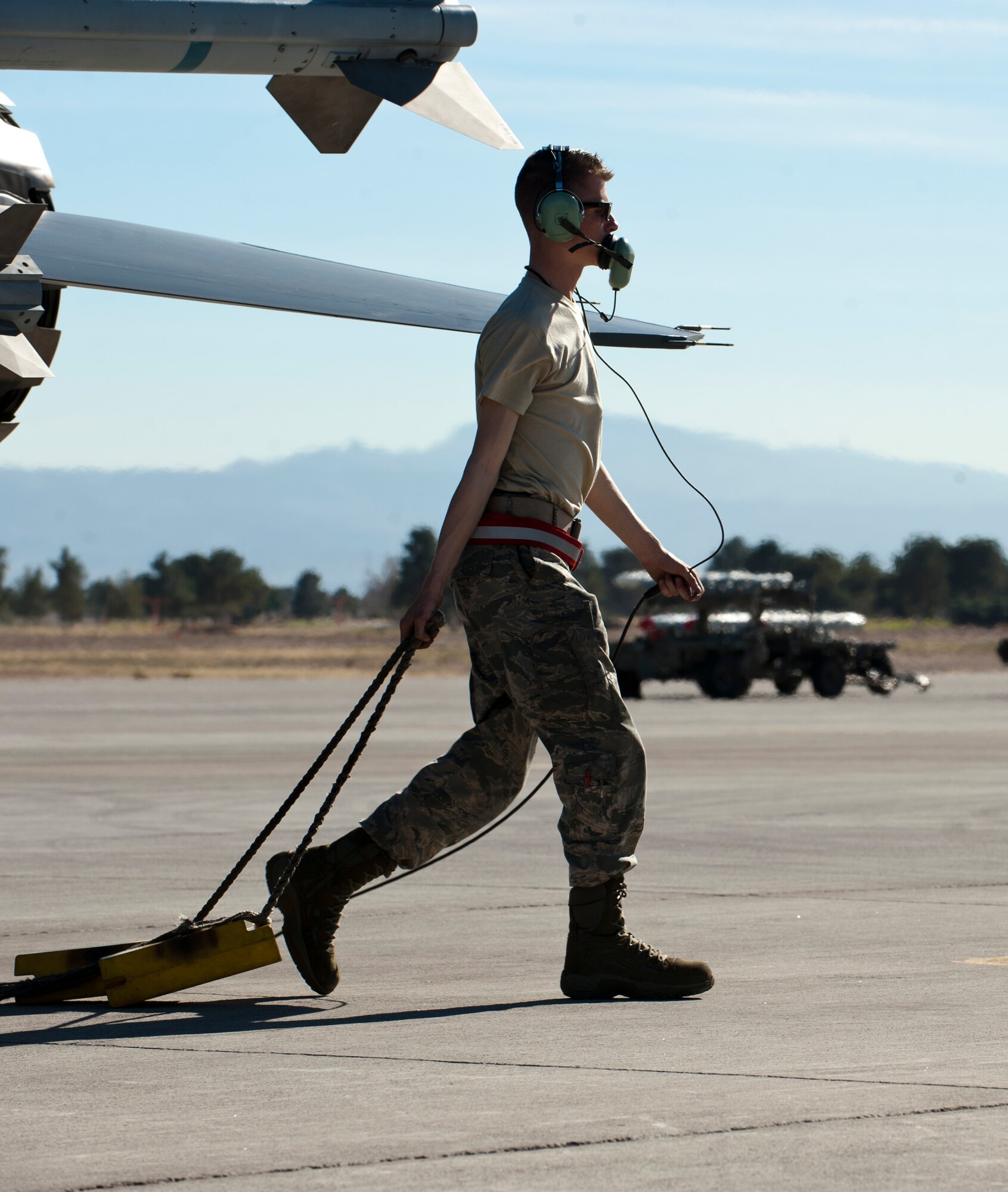 Airman 1st Class Andrew Galeener, an F-16 Fighting Falcon crew chief assigned to the 158th Fighter Wing, Burlington Air National Guard Base, Vt., removes the chocks on an F-16 before a training mission during Red Flag 15-1 at Nellis Air Force Base, Nev., Feb. 4, 2015. Flying units from around the globe deploy to Nellis AFB to participate in Red Flag. The exercise is held four times a year and organized by the 414th Combat Training Squadron. (U.S. Air Force photo by Senior Airman Thomas Spangler)