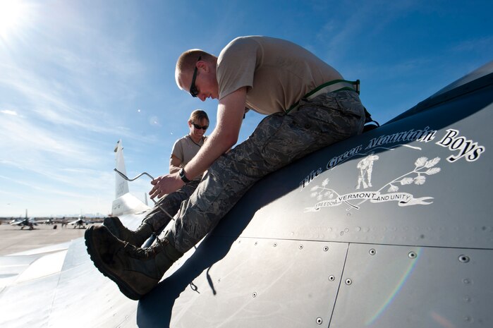 Tech. Sgt. Allison Shelp (background), and Staff Sgt. Josh Mitchell, both F-16 Fighting Falcon avionics technicians assigned to the 158th Fighter Wing, Burlington Air National Guard Base, Vt., perform maintenance on an F-16 during Red Flag 15-1 at Nellis Air Force Base, Nev., Feb. 4, 2015. Red Flag missions are conducted on the 2.9 million acres Nevada Test and Training Range with 1,900 possible targets, realistic threat systems and opposing enemy forces. (U.S. Air Force photo by Senior Airman Thomas Spangler)