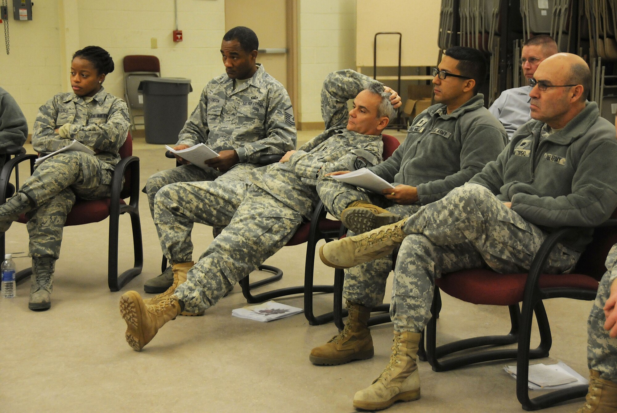 Army and Air Force chaplains and chaplain assistants from all over N.J., sit at a simulated discussion during the Traumatic Event Management Course Jan. 16, 2015, at Joint Base McGuire-Dix-Lakehurst, N.J. The scenario discussion took place after a fictitious plane crash and the members each had different roles to portray. In the center, Army Capt. Shawn Found, a chaplain from the 117th Combat Sustainment Support battalion, plays a character who doesn't want to participate and acts rude during the discussion. The Army's TEM course is a week long and focuses on unit cohesion and effectiveness to help manage crisis situations. The course focuses on group activities and role playing to reinforce the lessons. At the end of the week, the students are able to take what they learned and bring it back to their units. (U.S. Air National Guard Photo by Airman 1st Class Julia Pyun/Released)