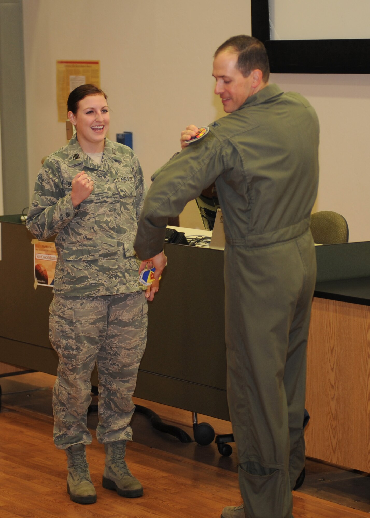 U.S. Air Force Col. James Meger, 355th Fighter Wing commander, attaches a patch to his uniform that was presented by Cadet Col. Riley Sullivan, Det. 020 Air Force Reserve Officers' Training Corps cadet wing commander, at the University of Arizona in Tucson, Ariz., Feb. 4, 2015. After Meger spoke to the cadets, Sullivan presented him with the Det. 020 patch and coin to thank him for taking the time to mentor them on how to become successful AF leaders. (U.S. Air Force photo by Airman 1st Class Cheyenne Morigeau/Released)