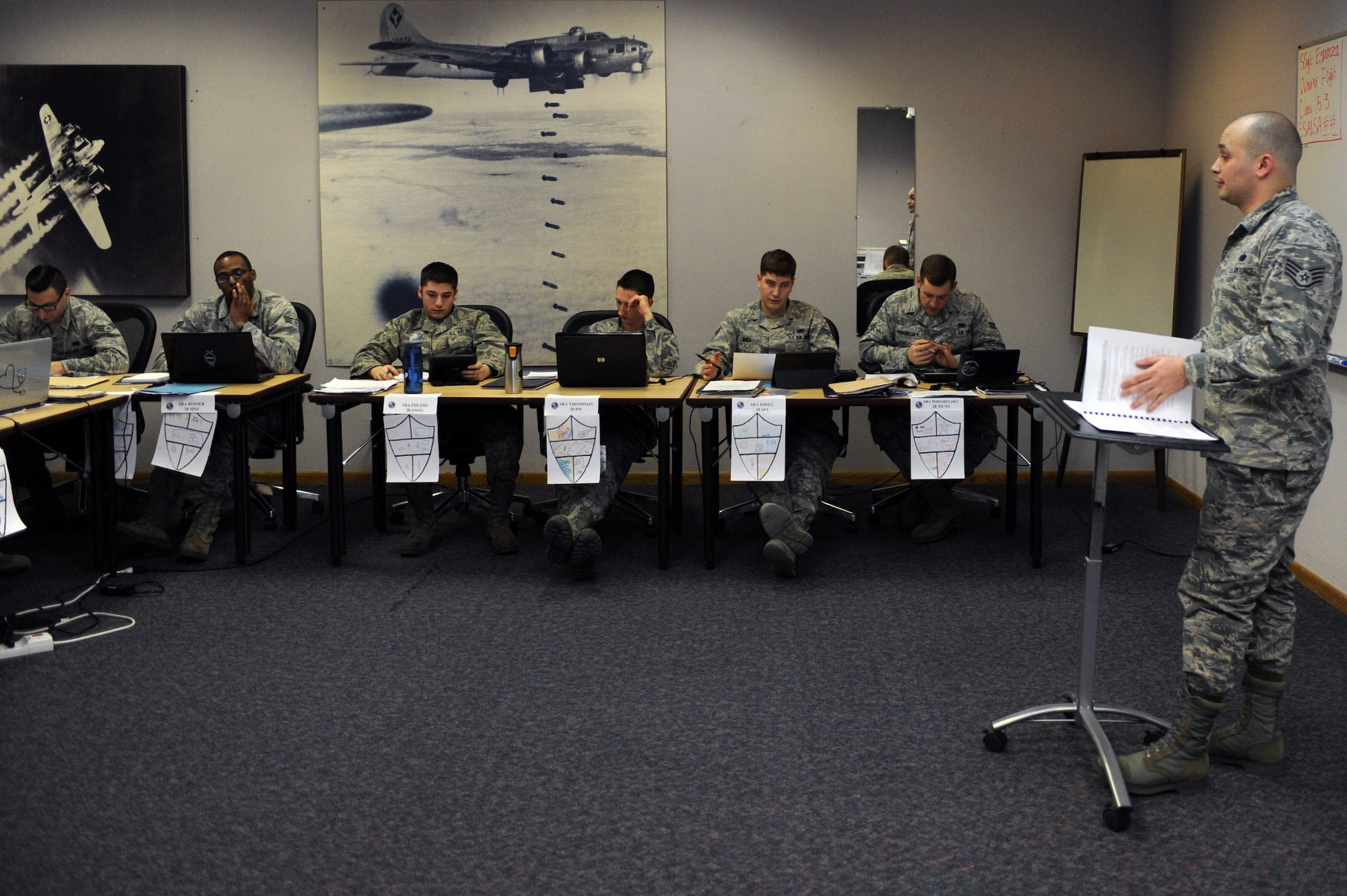 Staff Sgt. Anthony Espinoza, 28th Force Support Squadron Airman Leadership School instructor, reviews homework with Airman Leadership School Class 15-3 at Ellsworth Air Force Base, S.D., Jan. 29, 2015. Airman Leadership School is a five-week program designed to develop Senior Airmen into front-line supervisors while emphasizing management styles and effective leadership. (U.S. Air Force photo by Senior Airman Hailey R. Staker/Released)