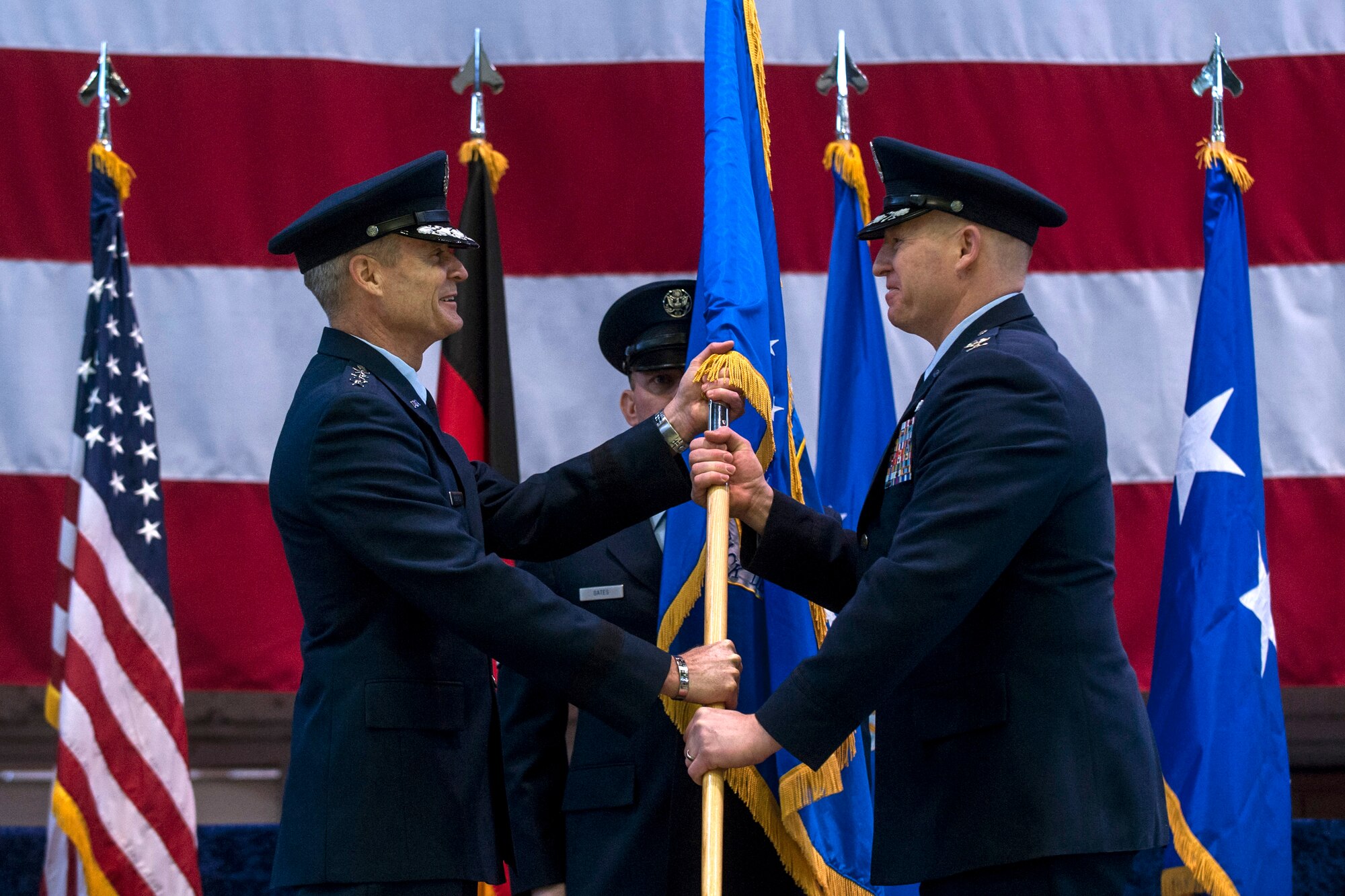 U.S. Air Force Lt. Gen. Darryl Roberson, 3rd Air Force commander, passes the 52nd Fighter Wing guidon to U.S. Air Force Col. Joseph McFall, 52nd FW commander, during an assumption of command ceremony Feb. 5, 2015, in Hangar 1 at Spangdahlem Air Base, Germany. During the ceremony, McFall, a former 52nd FW vice commander, assumed command of five groups, 24 squadrons, 16 geographically separated units spread across five countries with approximately 8,100 active duty military members, family members, U.S. civilians, host-nation employees and retirees. (U.S. Air Force photo by Senior Airman Rusty Frank/Released)