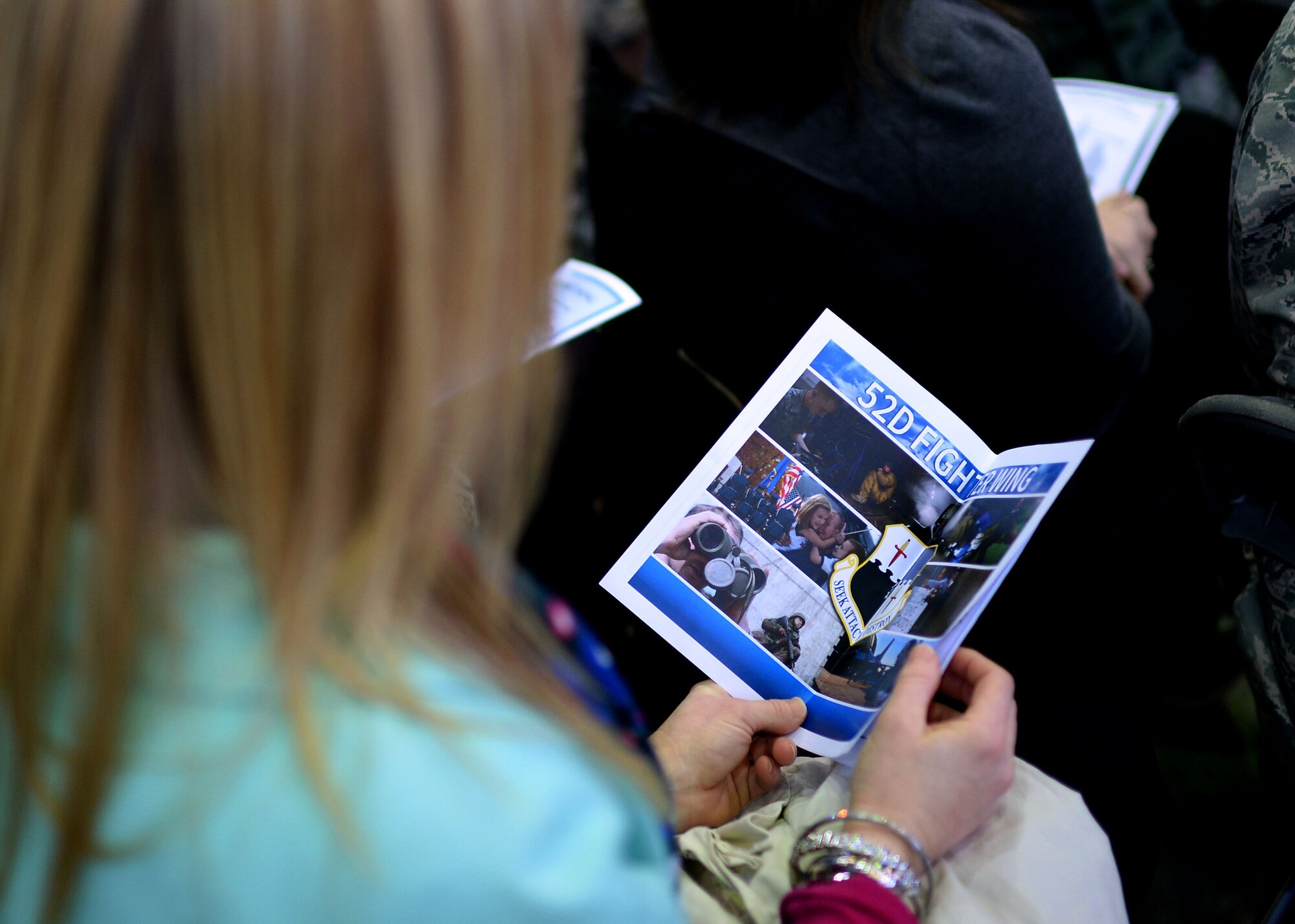 A participant of the 52nd Fighter Wing assumption of command ceremony looks at the program guide in Hangar 1 at Spangdahlem Air Base, Germany, Feb. 5, 2015. Nearly 400 people attended the event to witness U.S. Air Force Col. Joseph McFall accept responsibility as the wing commander. (U.S. Air Force photo by Staff Sgt. Daryl Knee/Released)