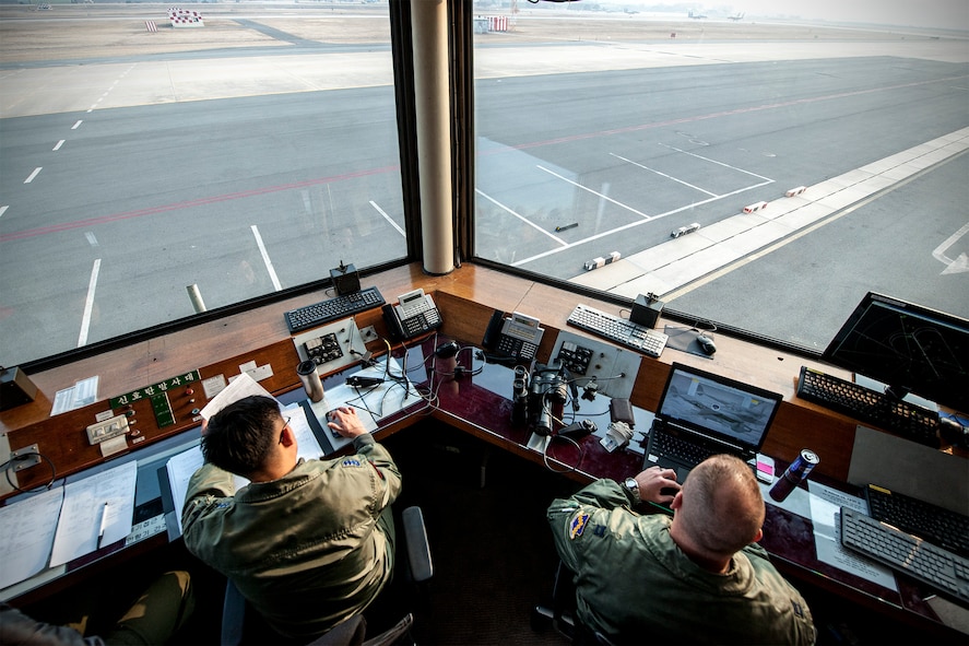 Capt. Justin Ankenbruck, 80th Fighter Squadron F-16 Fighting Falcon pilot, (right) and Capt. Sung Kwang Jang, 102nd Fighter Squadron F-15K Slam Eagle pilot, monitor sortie takeoffs from a runway control house during Exercise Buddy Wing 15-2 at Daegu Air Base, Republic of Korea, Feb. 5, 2015. During this iteration of Buddy Wing, Wolf Pack Airmen deployed to Daegu to trained alongside Airmen of the 11th Fighter Wing, learning how to operate as one force with dissimilar fighter aircraft. (U.S. Air Force photo by Senior Airman Katrina Heikkinen/Released)