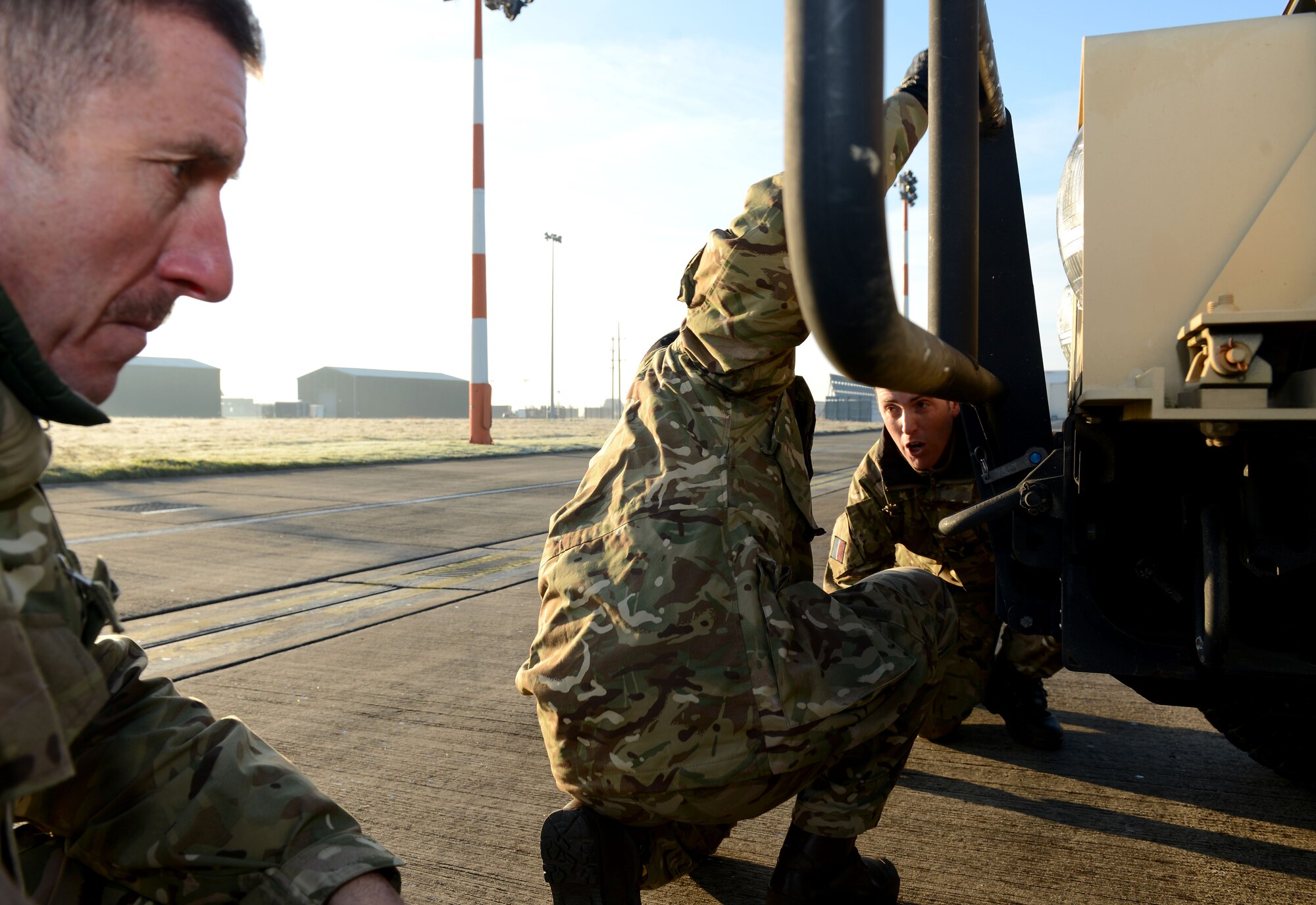 From left, Royal Air Force Warrant Officer Mark Taylor, Flt. Lt. Craig Rawlins and Senior Aircraftman Oliver Parsons, Joint Air Delivery trials and evaluations unit members, inspect a Humvee during training Jan. 20, 2015, on RAF Mildenhall, England. The RAF members worked with members of the 352nd Special Operations Support Squadron deployed aircraft ground response element to practice loading and unloading the Humvee in preparation for their upcoming joint training exercise, Emerald Warrior, held at Hurlburt Field, Fla. (U.S. Air Force photo by Senior Airman Kate Maurer/Released)