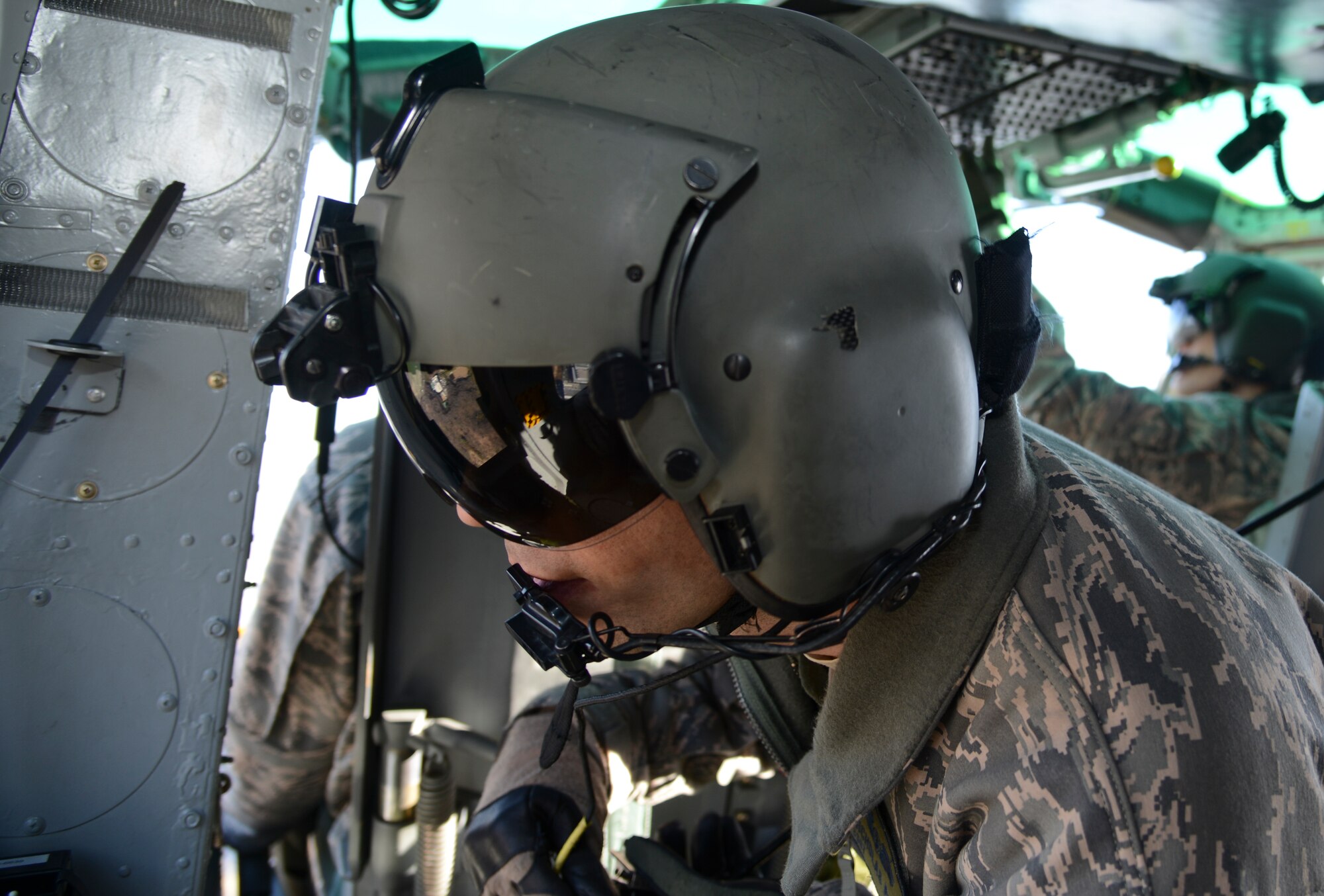 U.S. Air Force Staff Sgt. Nicholas Poe, 459th Airlift Squadron special missions aviator, checks the surroundings outside of the UH-1 Huey helicopter during a bilateral training mission Jan. 29, 2015, at Tokyo, Japan. Two Huey helicopters with both U.S. and Japanese service members conducted bilateral training. (U.S. Air Force photo by Senior Airman Michael Washburn/Released)