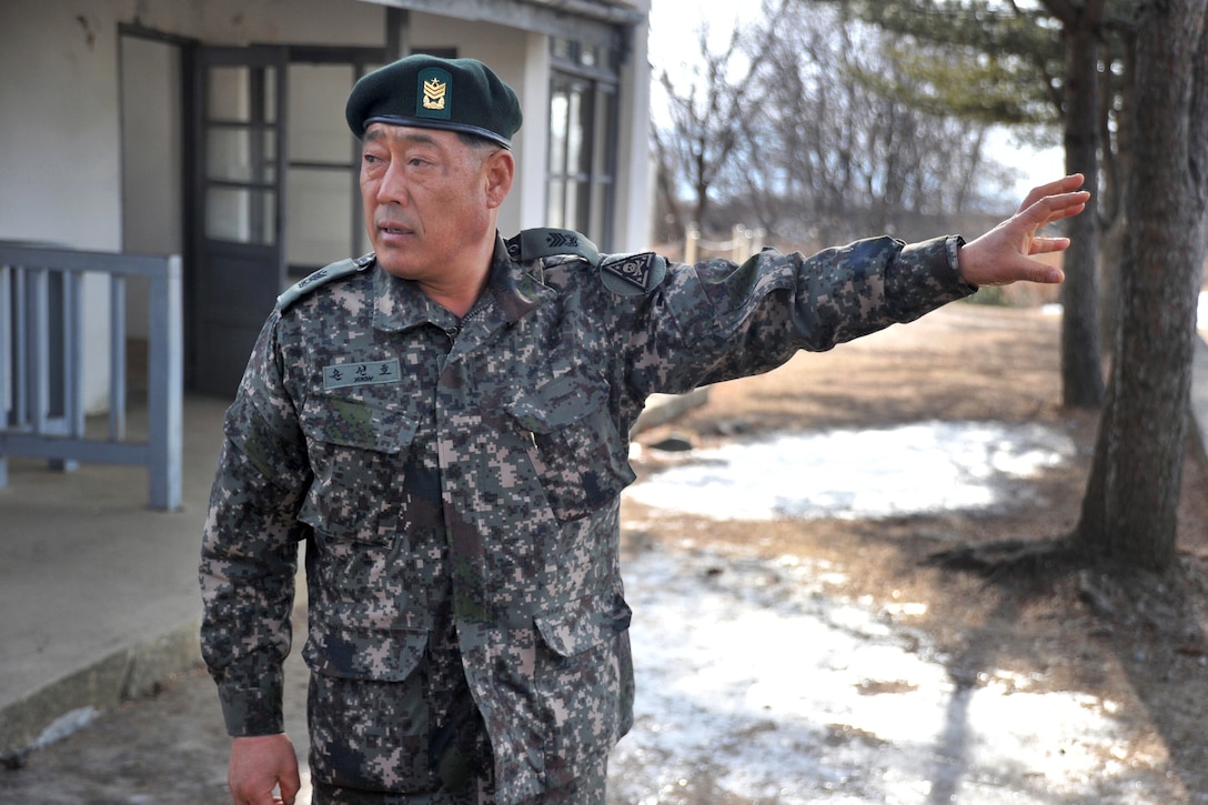 South Korean Command Sgt. Maj. Seon Ho-yoon, South Korean 3rd Infantry Division, explains the history of a former North Korean building known to once house and torture Korean soldiers leading up to the Korean War to U.S. Marine Corps Sgt. Maj. Bryan Battaglia, senior enlisted advisor to the chairman of the Joint Chiefs of Staff, South Korean Command Sgt. Maj. Lee Gil-ho and U.S. Army Command Sgt. Maj. John Troxell, senior enlisted advisor to U.S. Forces Korea, during a tour at the demilitarized zone in Pocheon, South Korea, Feb. 4, 2015.