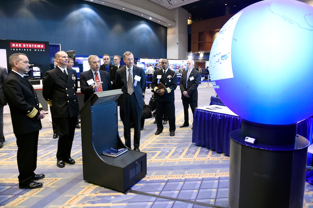 Dr. Reginald Beach, Office of Naval Research program officer for littoral geosciences and optics, discusses sponsored research on the changing sea ice, ocean and atmosphere with Navy Adm. Jonathan Greenert, Chief of Naval Operations, during a tour of the exhibit hall at the Naval Future Force Science and Technology EXPO in Washington, D.C., Feb. 4, 2015.