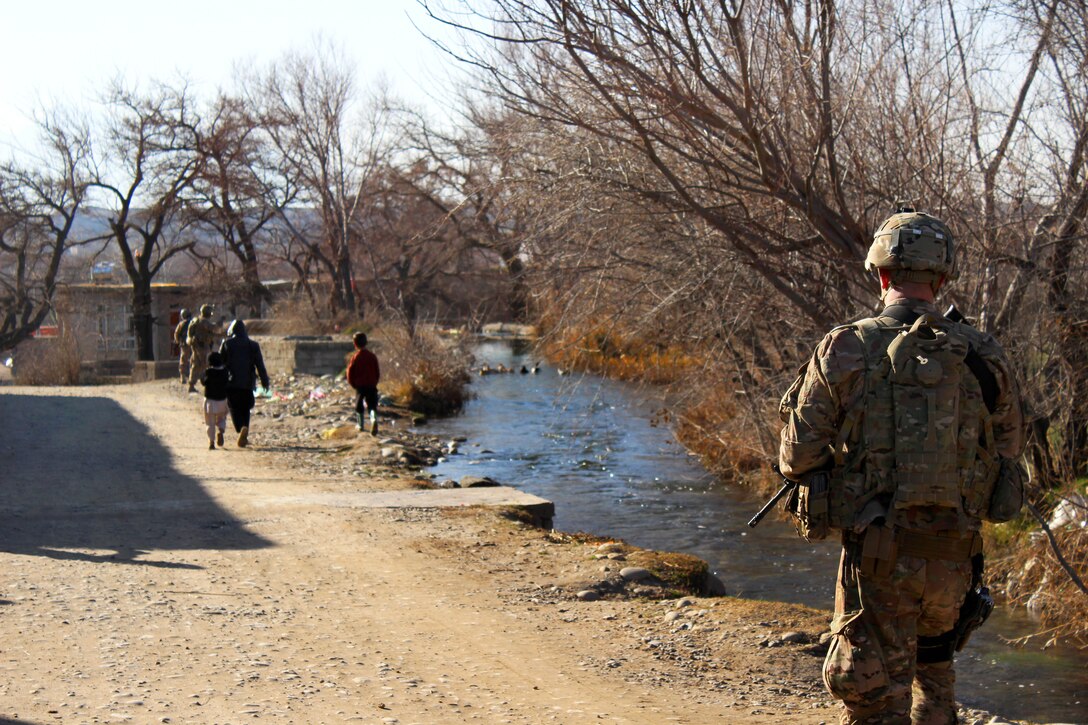 U.S. Army Sgt. Christopher Brown, right foreground, patrols along a creek with U.S., Czech and Afghan soldiers as they pass through a village in Parwan province, Afghanistan, Jan. 27, 2015. Brown is assigned to the 3rd Infantry Division's 2nd Squadron, 3rd Cavalry Regiment.