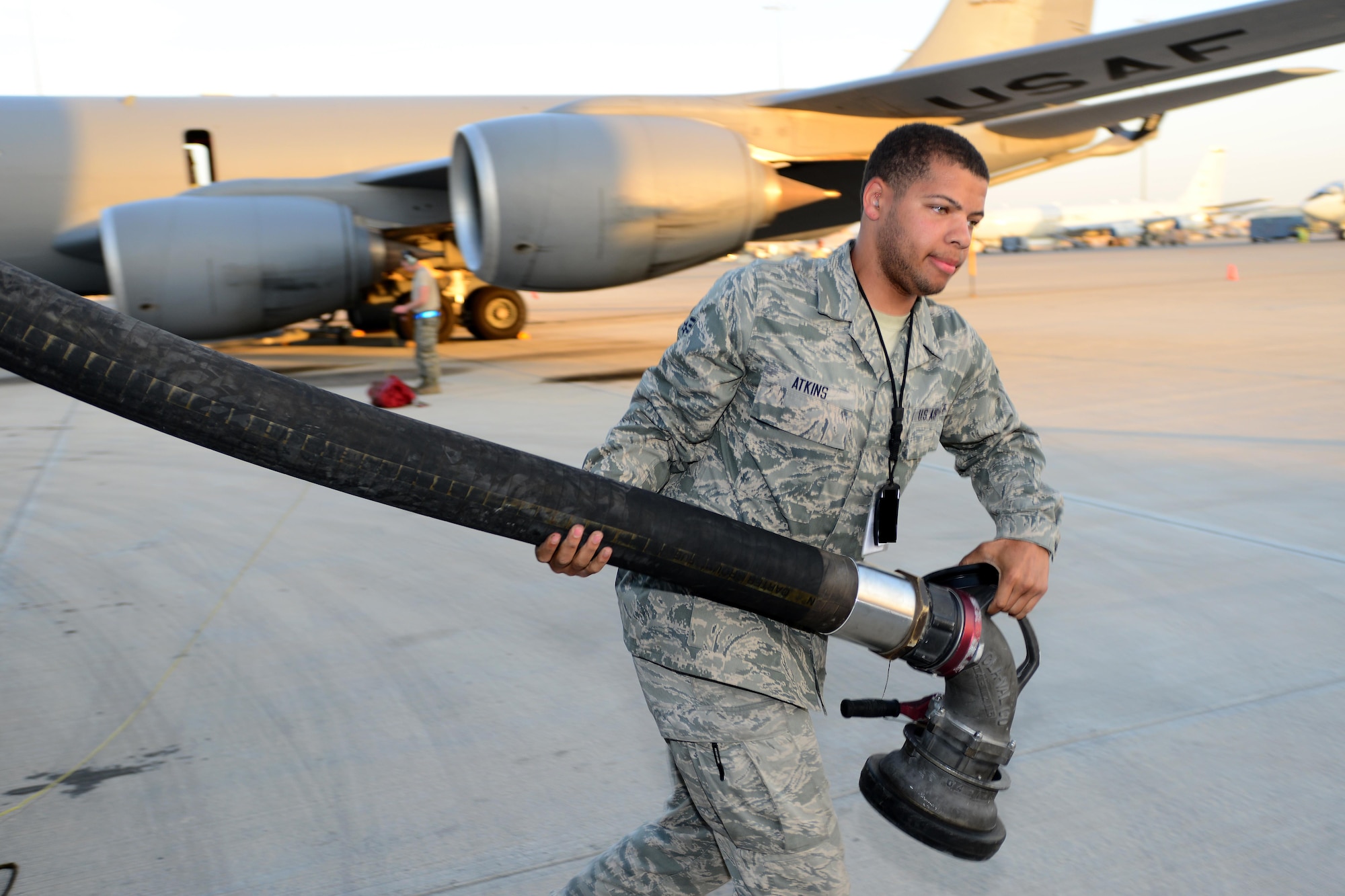Airman 1st Class Jovonte Atkins, 379th Expeditionary Logistics Readiness Squadron fuels specialist extends a fuels hose from a R-12 refueler to refuel an aircraft at Al Udeid Air Base, Qatar, Feb. 5, 2015. Since 2001, the 379th ELRS fuels flight has delivered more than three billion gallons of aviation and ground fuel in support of operations Enduring Freedom and Iraqi Freedom. (U.S. Air Force photo by Master Sgt. Kerry Jackson)   
