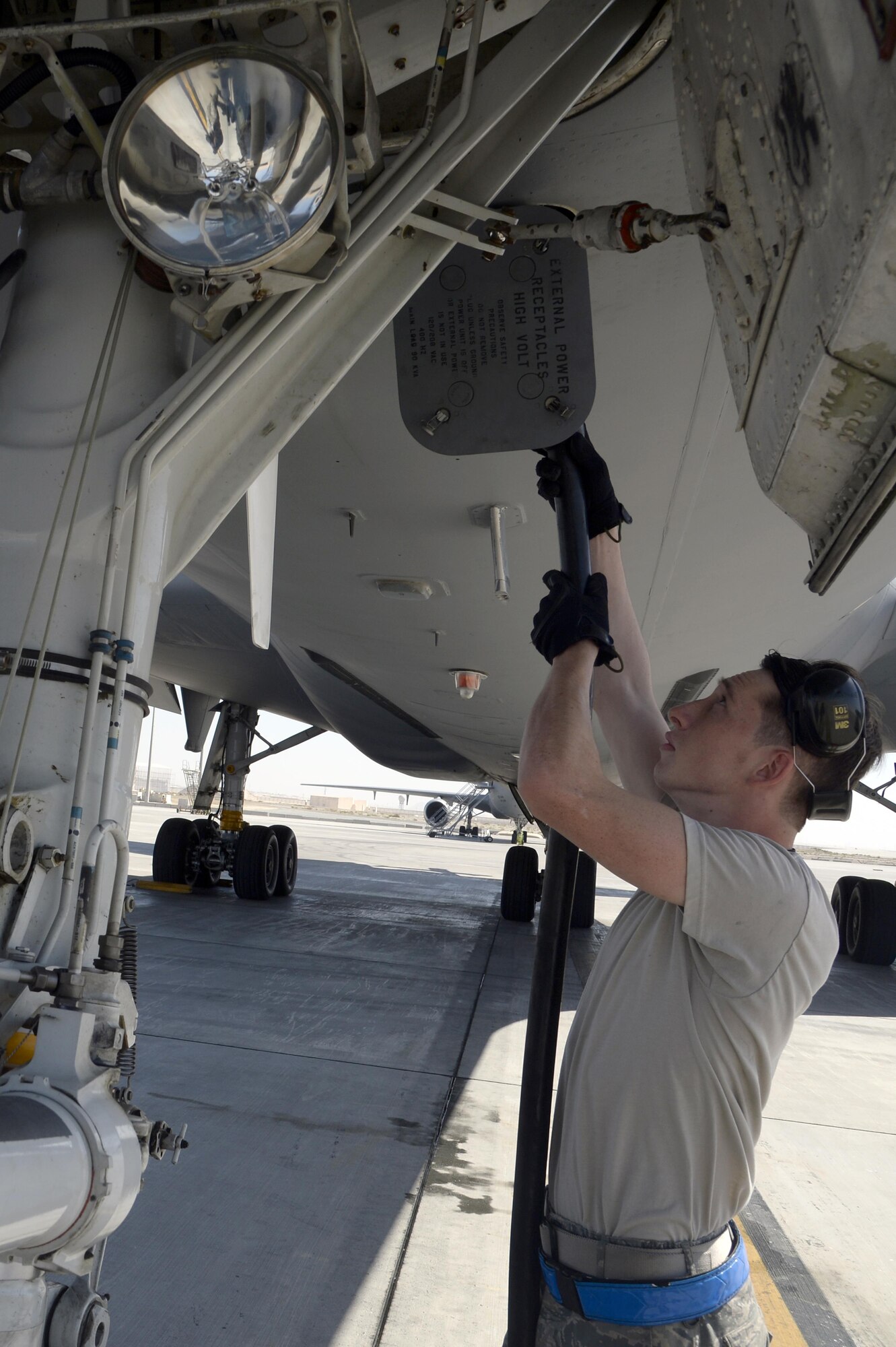 Senior Airman Will, KC-10 Extender instrument and flight control systems technician, connects a power cable from a generator to a KC-10 Extender at an undisclosed location in Southwest Asia Feb. 2, 2015. Specialists consist of hydraulics, electrical-environmental, jet engine, instrument and flight control systems and communication/navigation shops that perform the specialized maintenance required to keep the Extender in the air. Will is deployed from Travis Air Force Base, Calif., and is a native of Glendale, Ariz. (U.S. Air Force photo/Tech. Sgt. Marie Brown)