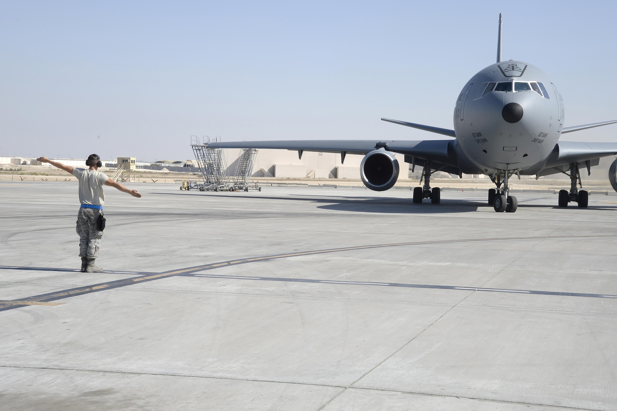 Airman 1st Class Taylor, KC-10 Extender crew chief, marshals out a KC-10 Extender at an undisclosed location in Southwest Asia Feb. 2, 2015. Since the beginning of Operation Inherent Resolve the KC-10 Extender has supplied over 150 million pounds of fuel to a variety of U.S. and allied military aircraft. Taylor is currently deployed from Travis Air Force Base, Calif., and is a native of Belleview, S.D. (U.S. Air Force photo/Tech. Sgt. Marie Brown) 