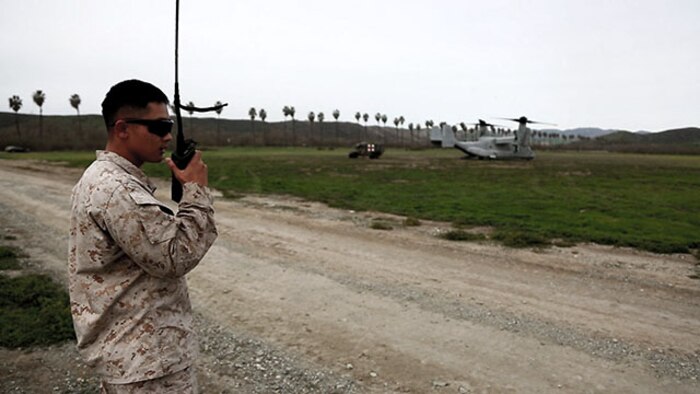 A data network specialist from Headquarters Regiment, 1st Marine Logistics Group, communicates with an MV-22 Osprey pilot during an en-route care exercise aboard Camp Pendleton, Calif., Jan. 28, 2015. During the four-day exercise, corpsmen trained to prepare a Special-Purpose Marine Air-Ground Task Force group that is going to forward deploy later this year. The more than 40 corpsmen set up a shock trauma platoon facility, or mobile emergency room, to treat simulated casualties. The casualties were stabilized in the STP and then flown out via aircraft. (U.S. Marine Corps photo by Sgt. Laura Gauna/Released)