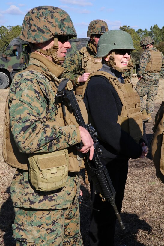 Jessica L. Wright, Under Secretary of Defense for Personnel and Readiness, and Staff Sgt. Mark A. Dickey, platoon sergeant, Battery A, Ground Combat Element Integrated Task Force, observe as field artillery cannoneers conduct a fire mission at Range G7, aboard Marine Corps Base Camp Lejeune, North Carolina, Feb. 5. Wright visited GCEITF Marines to observe their training and learn about the Marines in the Task Force. From October 2014 to July 2015, the GCEITF will conduct individual and collective level skills training in designated ground combat arms occupational specialties in order to facilitate the standards based assessment of the physical performance of Marines in a simulated operating environment performing specific ground combat arms tasks. (U.S. Marine Corps photo by Sgt. Alicia R. Leaders/Released)