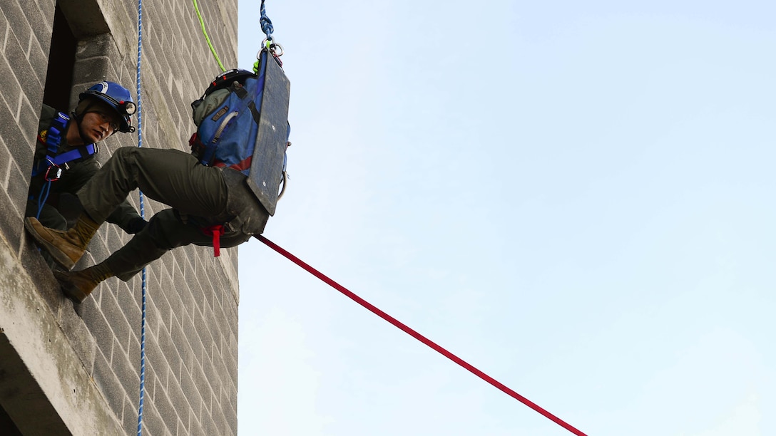 A simulated victim is rappelled down a tower during a rescue training scenario, Feb. 4, at Henrico Fire Drill Facility in Glen Allen, Virginia. During this scenario, Marines and sailors with Technical Rescue Platoon, Chemical Biological Incident Response Force, are responsible for quickly assisting a victim down a building, so the victim can receive further attention to wounds.