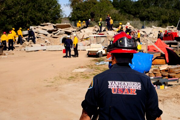 Essex Martinez observes Urban Search and Rescue (US&R) Task Force members during an exercise Feb. 2, 2015, at Lompoc, Calif. As part of a regional US&R team, Vandenberg firefighters trained alongside counterparts from local departments -- focusing on locating, extracting and stabilizing victims trapped in confined spaces. Martinez is the 30th Civil Engineer Squadron Urban Search and Rescue fire captain. (U.S. Air Force photo/Staff Sgt. Jim Araos)