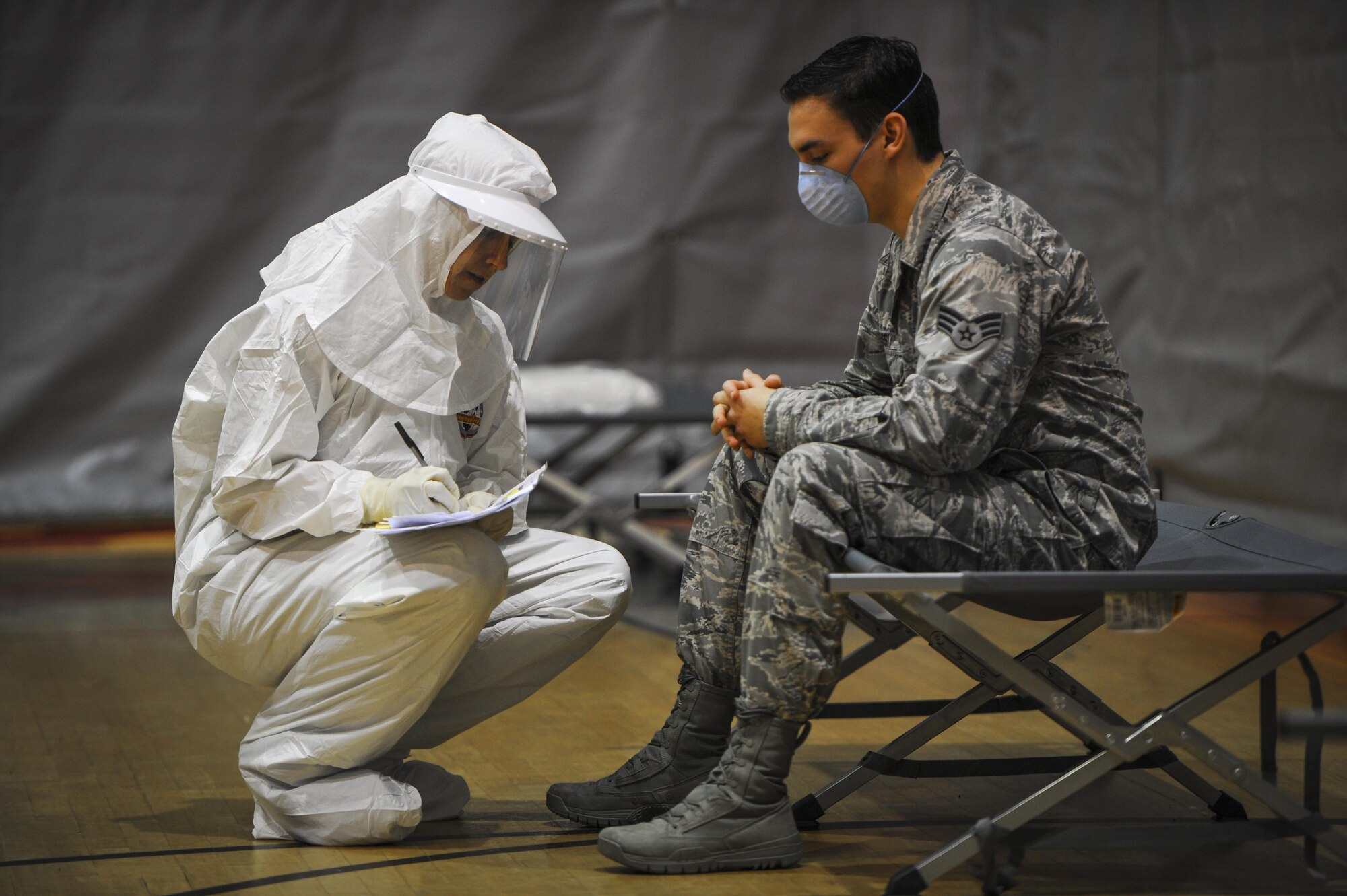 Senior Airman Magnus Russi, 1st Special Operations Medical Group aerospace medical technician, reports his simulated symptoms to Capt. Dawn Souza, 1st SOMDG nurse, during a disease containment exercise on Hurlburt Field, Fla., Feb. 4, 2015. The medical staff focused on the interaction and coordination between multiple units that would be involved in responding to a disease outbreak. (U.S. Air Force photo/Senior Airman Christopher Callaway)