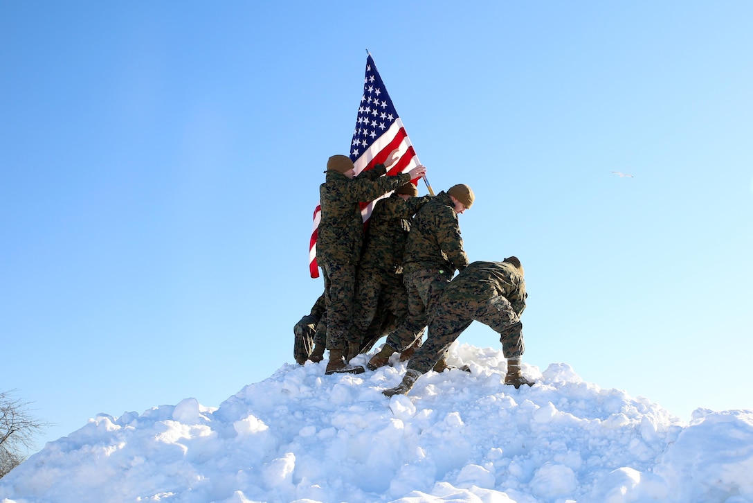 Marines with 9th Marine Corps District Headquarters, Marine Corps Recruiting Command, celebrate a major snowfall aboard Naval Station Great Lakes, Ill., Feb. 6, 2015, by recreating the flag raising on Iwo Jima. The Marines pictured (from right) are Cpl. Edgar R. TorresRoman, Sgt. Leonel T. Lopez, Sgt. Mary E. Kilbourne, Sgt. Jason R. Atherton, Cpl. Bradley D. Carrier, and Cpl. Luis A. Nietosoto. The 9th Midwest Marines recently relocated the district headquarters from Kansas City, Mo., to North Chicago, July 2014.
