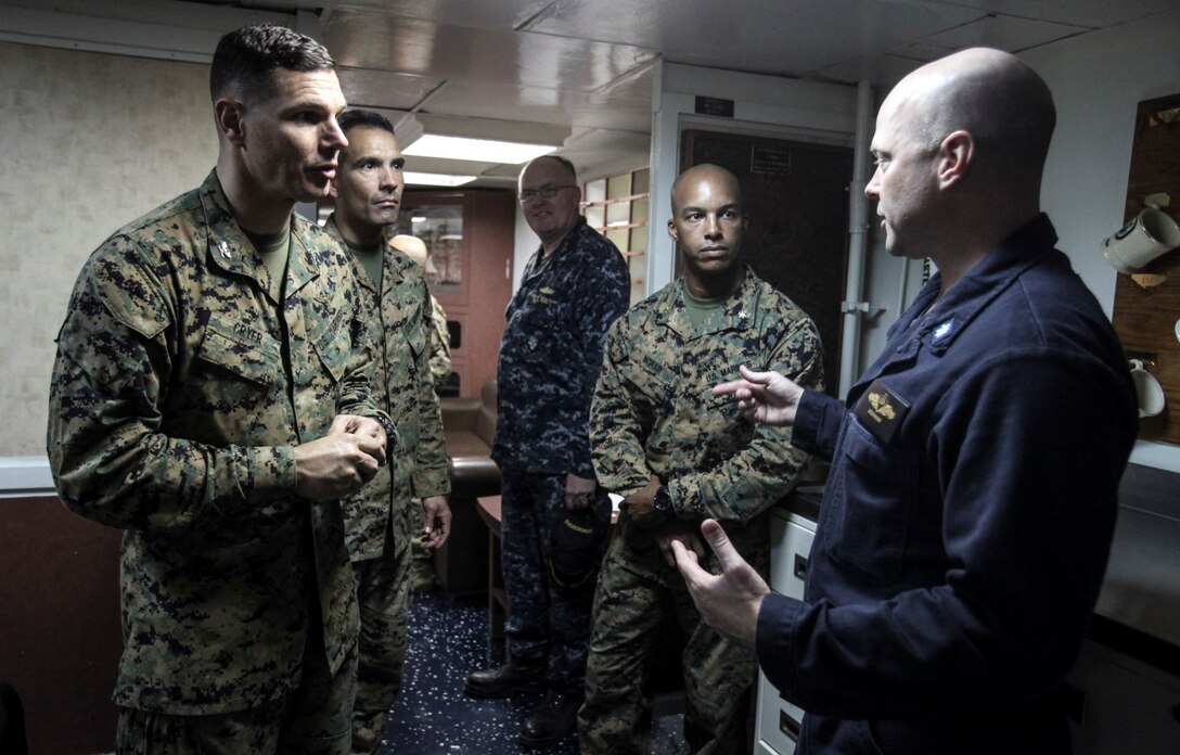 U.S. Marine Col. Vance L. Cryer, left, and Navy Cmdr. Thomas S. Stephens discuss current operation of the Marines and sailors aboard the USS Rushmore (LSD 47) off the coast of Camp Pendleton, Calif., Jan. 25, 2015. Cryer is the commanding officer of the 15th Marine Expeditionary Unit. Stephens is the commanding officer of the USS Rushmore. The 15th MEU was embarked aboard the three ships of the Essex Amphibious Ready Group - the USS Essex (LHD 2), USS Anchorage (LPD 23), and USS Rushmore – from Jan. 22-25 to familiarize themselves with the ships as they continue to prepare for their upcoming deployment this spring. (U.S. Marine Corps photo by Cpl. Steve H. Lopez/Released)