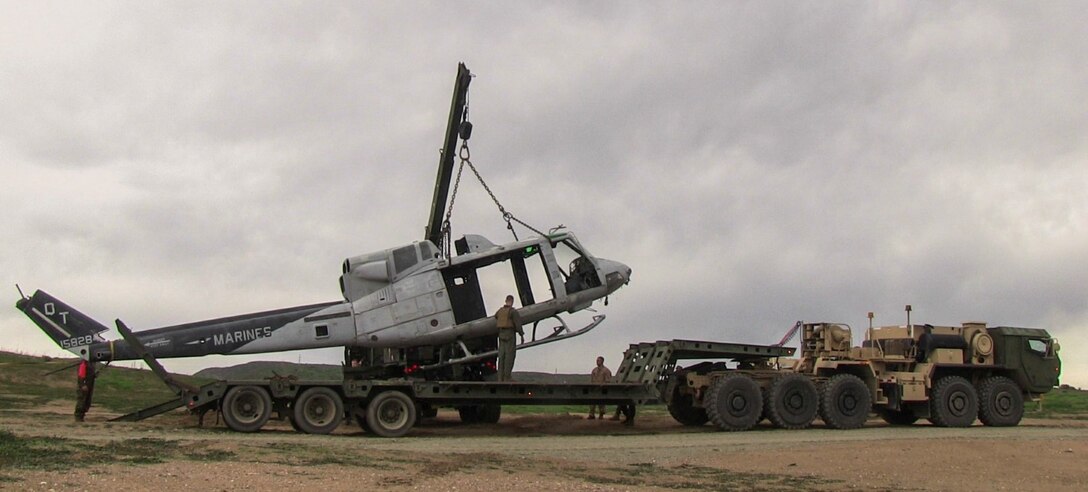 An MK36 wrecker places a helicopter hulk on the back of an M870M2 trailer during a ground tactical recovery of aircraft and personnel exercise with Combat Logistics Battalion 15, 15th Marine Expeditionary Unit, aboard Camp Pendleton, Calif., Jan. 29, 2015. As the 15th MEU’s combat logistics element, CLB-15 continues to hone its skills in environments similar to those they may find in future missions. (U.S. Marine Corps photo by Cpl. Steve H. Lopez/Released)