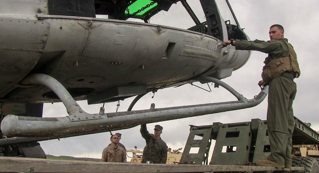 U.S. Marine Sgt. Ryan Neville, right, guides a helicopter hulk as it is placed on the back of an M870M2 trailer during a ground tactical recovery of aircraft and personnel exercise aboard Camp Pendleton, Calif., Jan. 29, 2015. Neville is a vehicle commander with Combat Logistic Battalion 15, 15th Marine Expeditionary Unit. As the 15th MEU’s combat logistics element, CLB-15 continues to hone its skills in environments similar to those they may find in future missions. (U.S. Marine Corps photo by Cpl. Steve H. Lopez/Released)