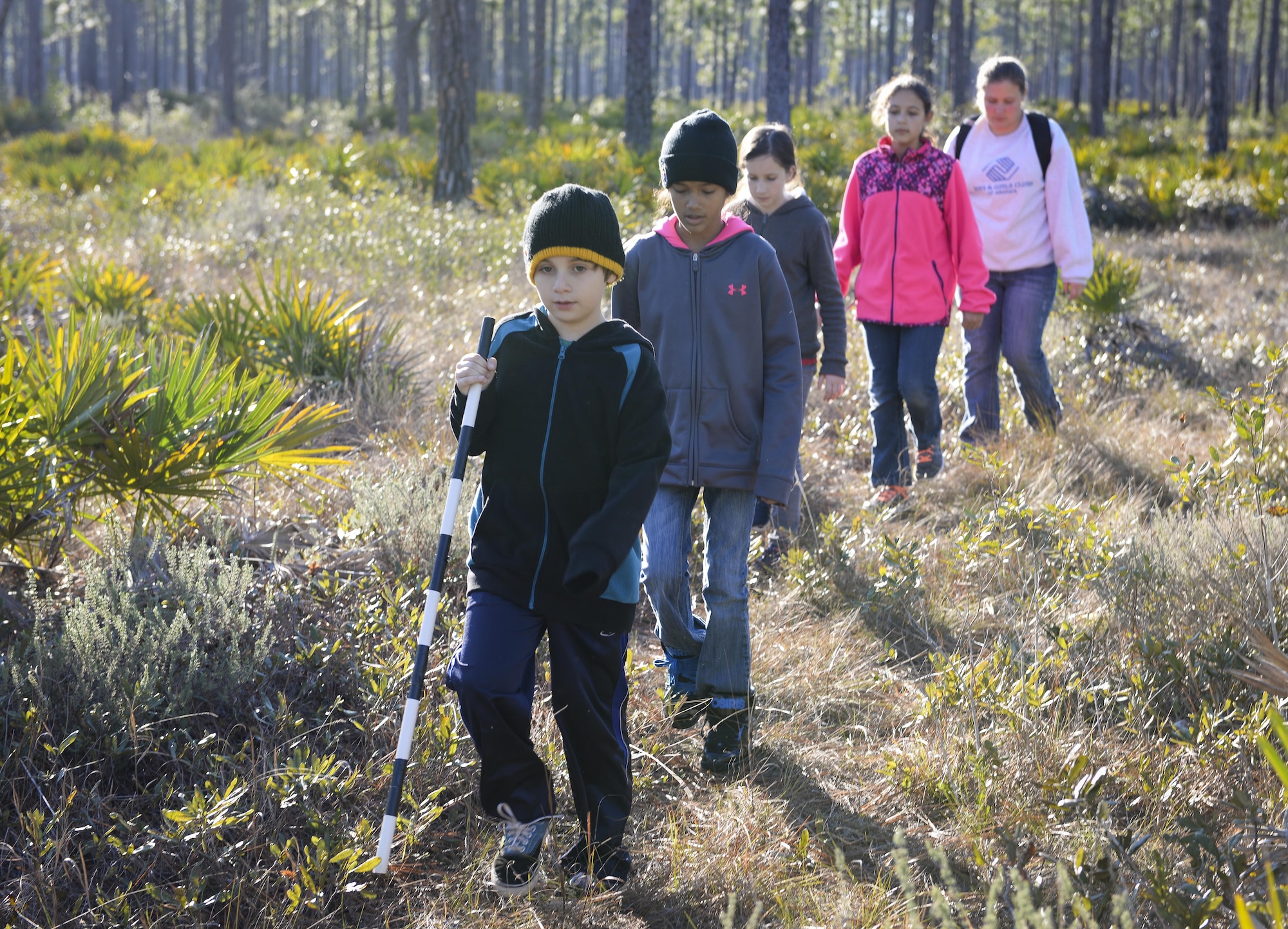Children from the Hurlburt youth group walk towards a wildlife camera at Hurlburt Field, Fla., Feb. 5, 2015. While searching for the cameras, the children were taught about cardinal directions, vegetation identification, hydrologic indicators, wildlife signs and more. (U.S. Air Force photo Senior Airman Meagan Schutter/Released)