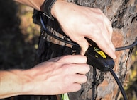 A lock attached to a camera is unlocked at Hurlburt Field, Fla., Feb. 5, 2015. Okaloosa Science Project deploys cameras for a period of three weeks, capturing wildlife at a distance, ranging from 8-15 meters, depending on topography and vegetation. (U.S. Air Force photo Senior Airman Meagan Schutter/Released)