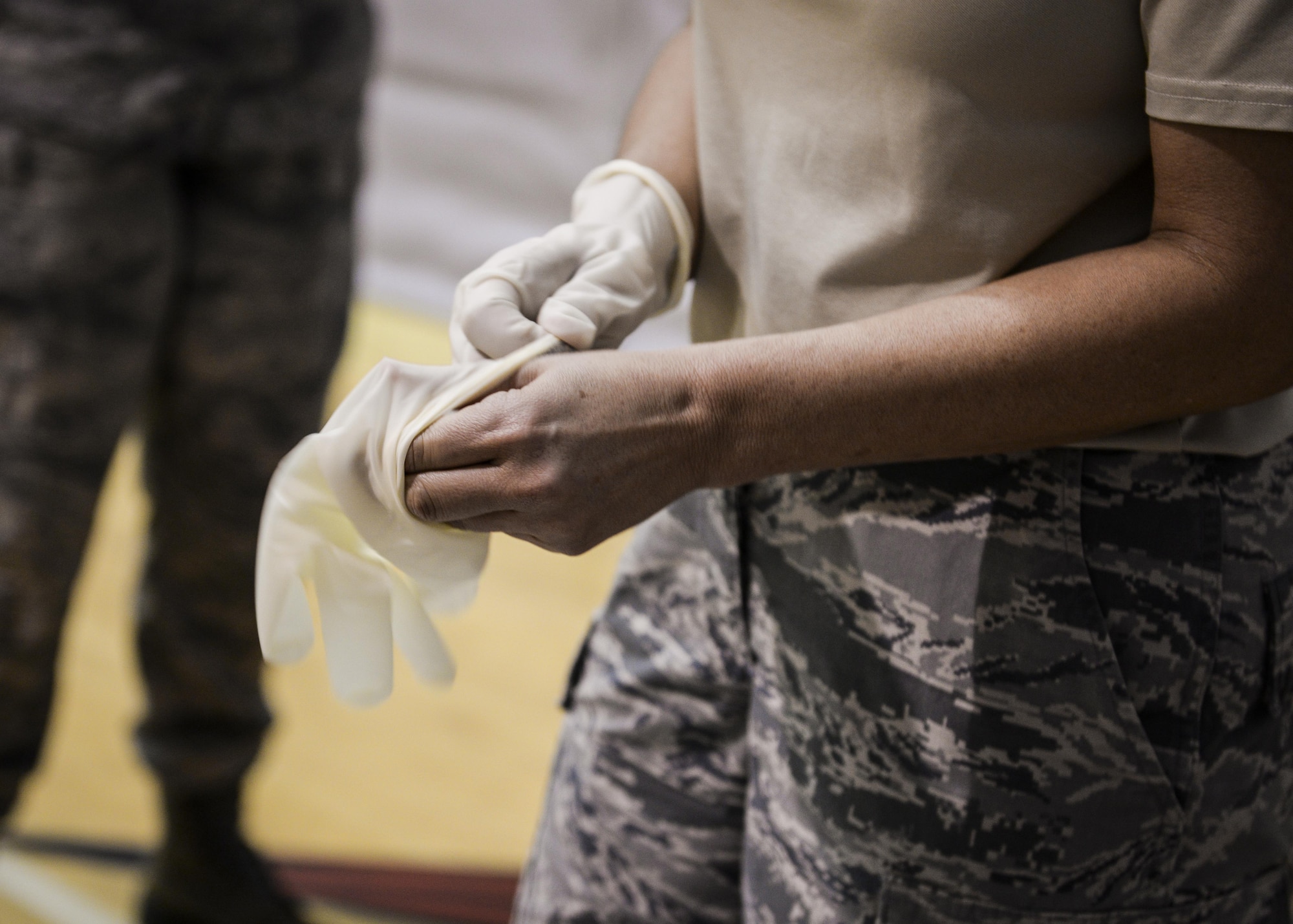 Capt. Dawn Souza from the 1st Special Operations Medical Group, dons gloves during a disease containment exercise at Hurlburt Field, Fla., Feb. 4, 2015. This exercise is an annual requirement that helps squadrons across Hurlburt to coordinate and work together to ensure they are properly trained to react to a disease on base, as well as in the community. (U.S. Air Force photo Senior Airman Meagan Schutter/Released)