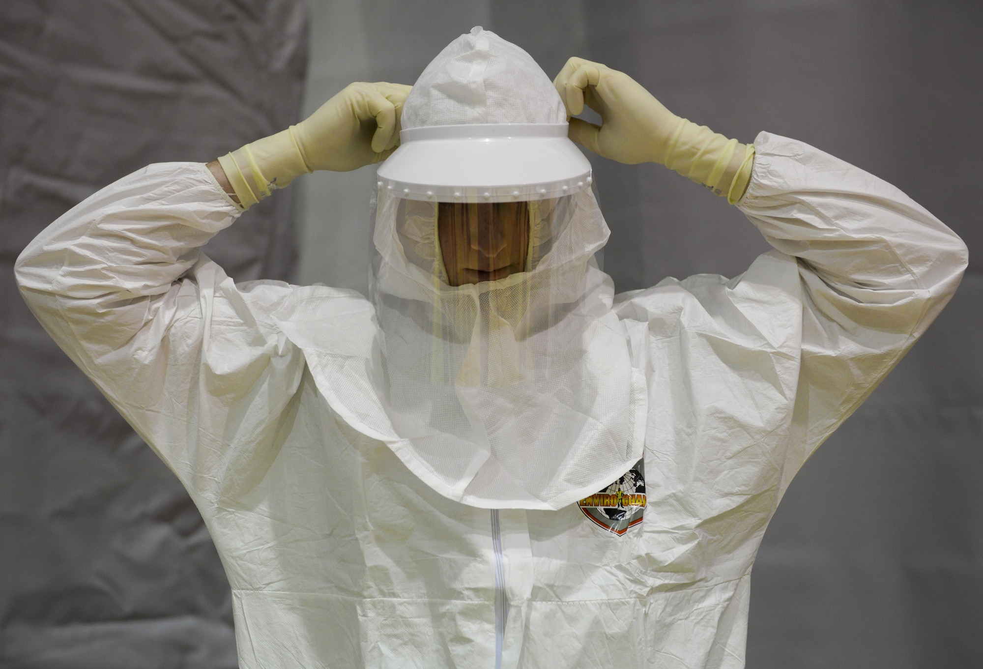 Airman 1st Class Brandon Culpan, 1st Special Operations Medical Group health service technician, dons personal protective equipment during a disease containment exercise at Hurlburt Field, Fla., Feb. 4, 2015. The exercise focused on a disease outbreak that is potentially contagious and relevant to what is happening in the real world. (U.S. Air Force photo Senior Airman Meagan Schutter/Released)