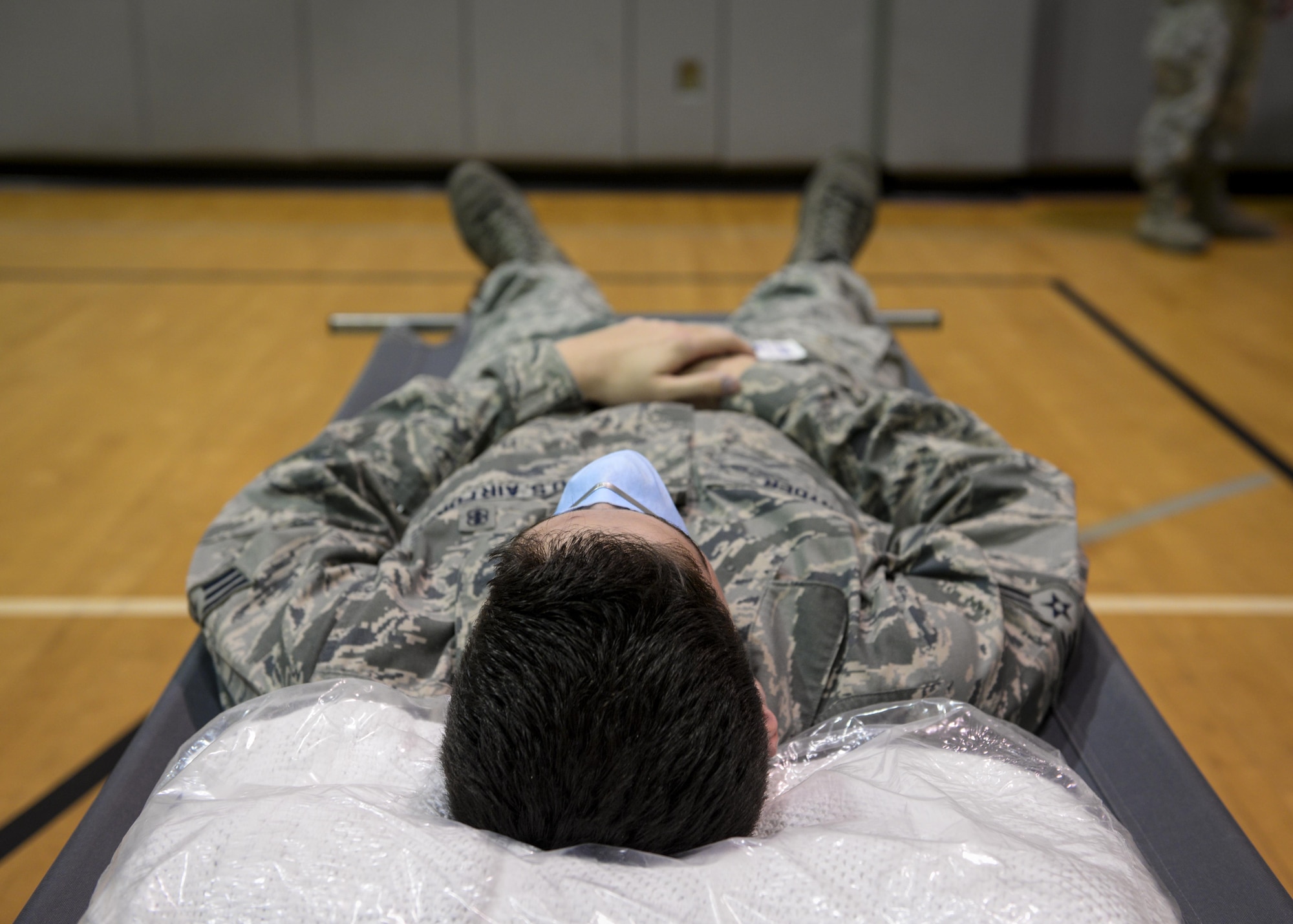 Senior Airman John Snyder, 1st Special Operations Medical Group command support staff, rests on a cot during a disease containment exercise at Hurlburt Field, Fla., Feb. 4, 2015. This exercise is an annual requirement that helps squadrons across Hurlburt to coordinate and work together to ensure they are properly trained to react to a disease on base, as well as in the community. (U.S. Air Force photo Senior Airman Meagan Schutter/Released)