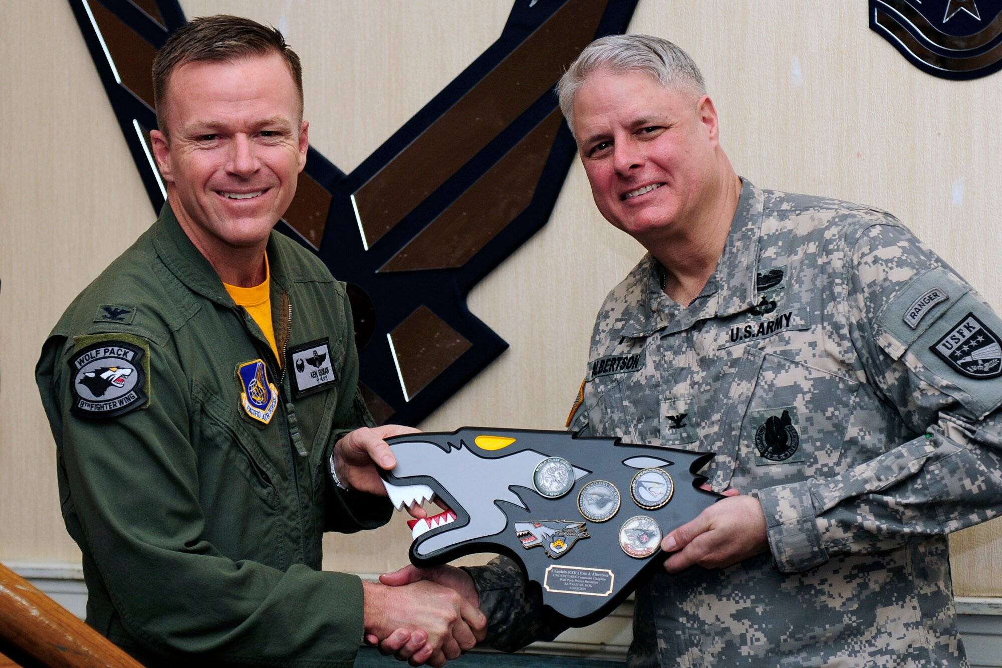 U.S.  Air Force Col. Ken “Wolf” Ekman, 8th Fighter Wing commander (left), presents a gift to U.S. Army Col. Eric Albertson, United Nations Command, Combined Forces Command, and U. S. Forces Korea command chaplain, during the 2015 National Prayer Breakfast at Kunsan Air Base, Republic of Korea, Feb. 6, 2015. Albertson was the guest speaker for the event and spoke on the importance of serving with integrity. (U.S. Air Force photo by Senior Airman Taylor Curry/Released) 