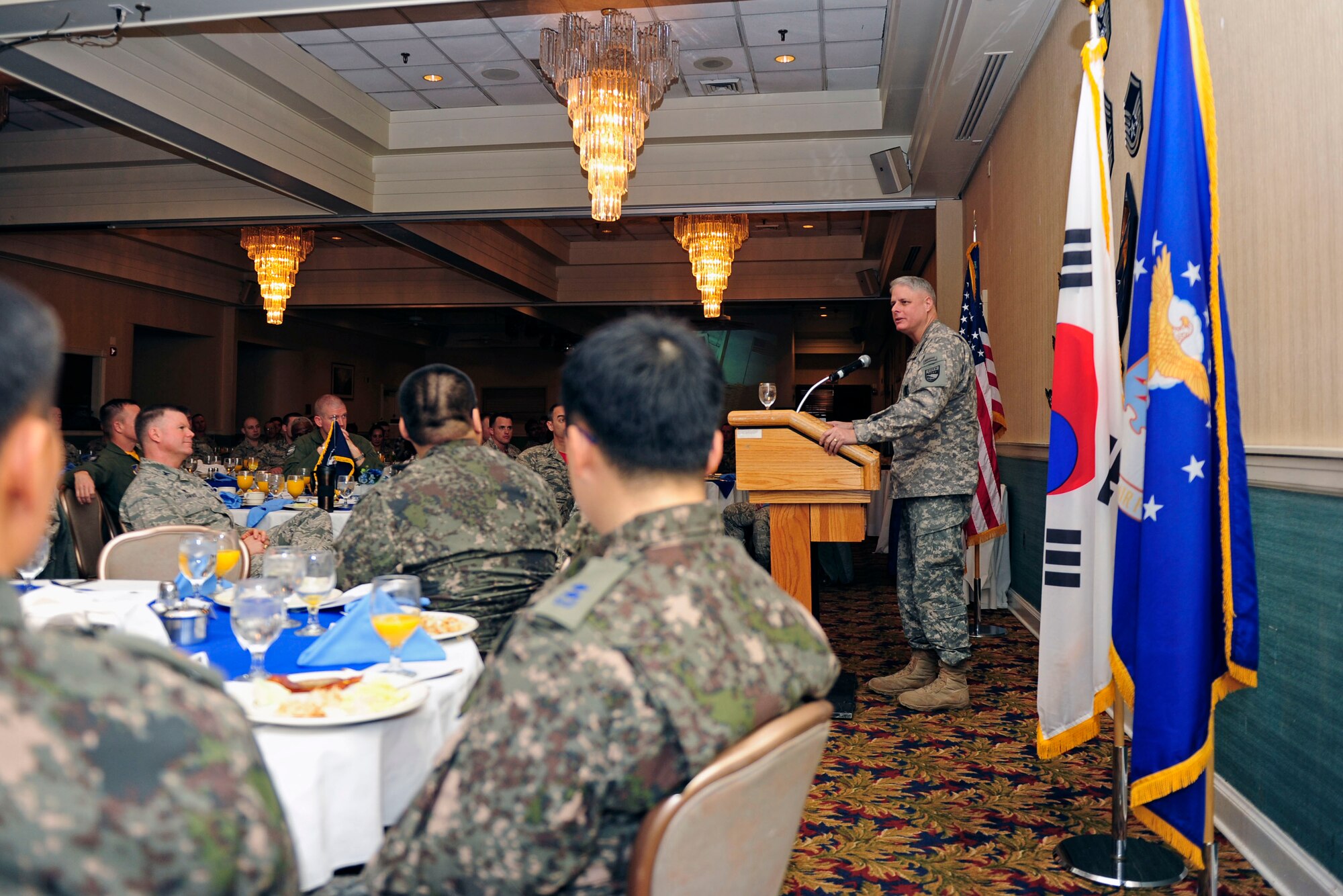 Approximately 200 members of the 8th Fighter Wing and Republic of Korea Air Force 38th Fighter Group listen to U.S. Army Col. Eric Albertson, United Nations Command, Combined Forces Command, and U. S. Forces Korea command chaplain, as he delivers remarks during the National Prayer Breakfast at Kunsan Air Base, ROK, Feb. 6, 2015. Albertson was the guest speaker for the event and spoke on the importance of serving with integrity. (U.S. Air Force photo by Senior Airman Taylor Curry/Released)