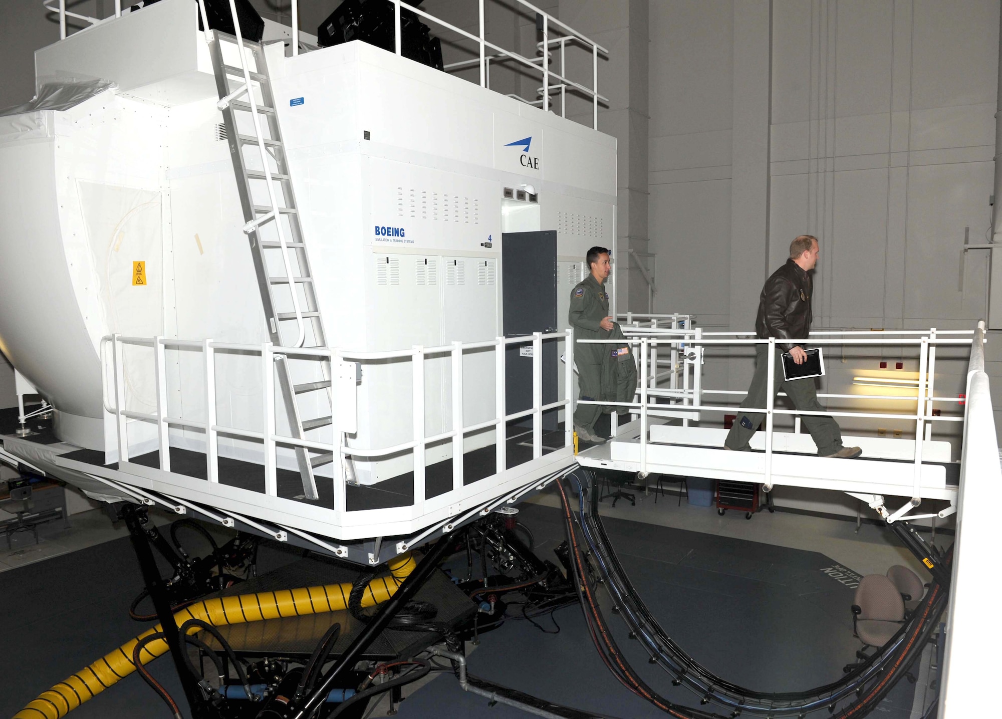 (Left) First Lt. John Quirarte, 349th Air Refueling Squadron pilot, and Capt. Adam Johnson, 344th ARS pilot, exit a KC-135 simulator after a two-hour training session. Pilots are required to participate in a minimum of at least five simulator sessions each year in order to keep their skills sharp and practice handling in-flight emergencies. (U.S. Air Force photo/ Airman 1st Class Tara Fadenrecht)
