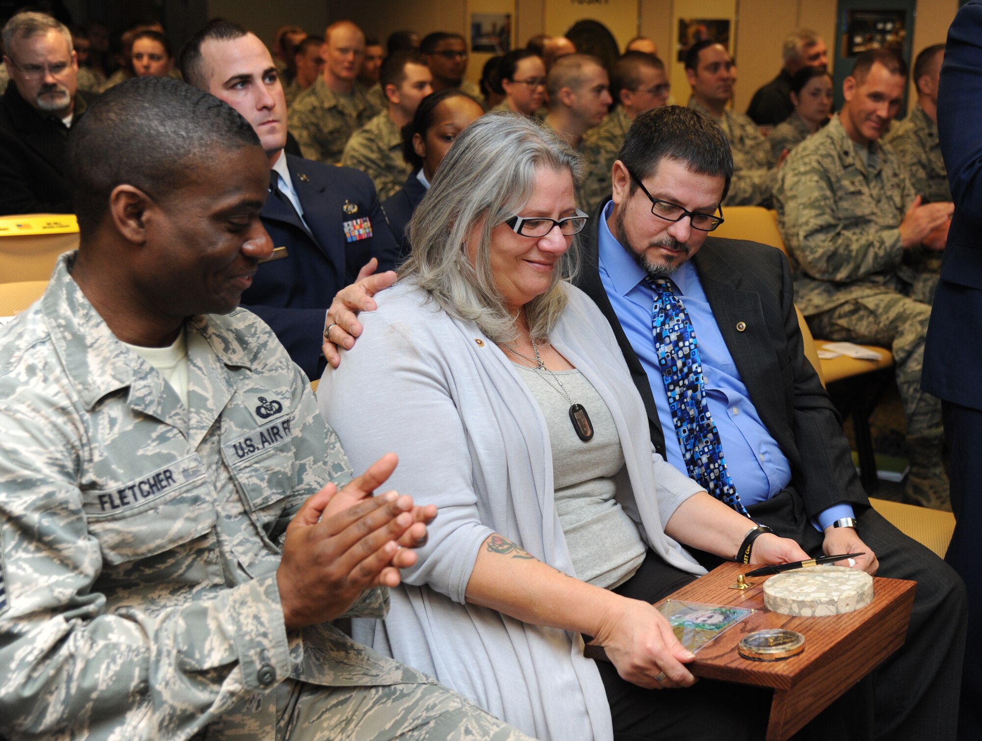 Retired Master Sgt. Richard Hansen Sr., and his wife, Emily, admire a plaque received during a dedication ceremony to honor their son, Senior Airman James Hansen, Feb. 4, 2015, at Cody Hall, Keesler Air Force Base, Miss.  Hansen was killed in combat in Iraq on Sept. 15, 2010.  He was an airfield management operations coordinator and received his training from the 334th Training Squadron here.  A training room was dedicated during the event. (U.S. Air Force photo by Kemberly Groue)