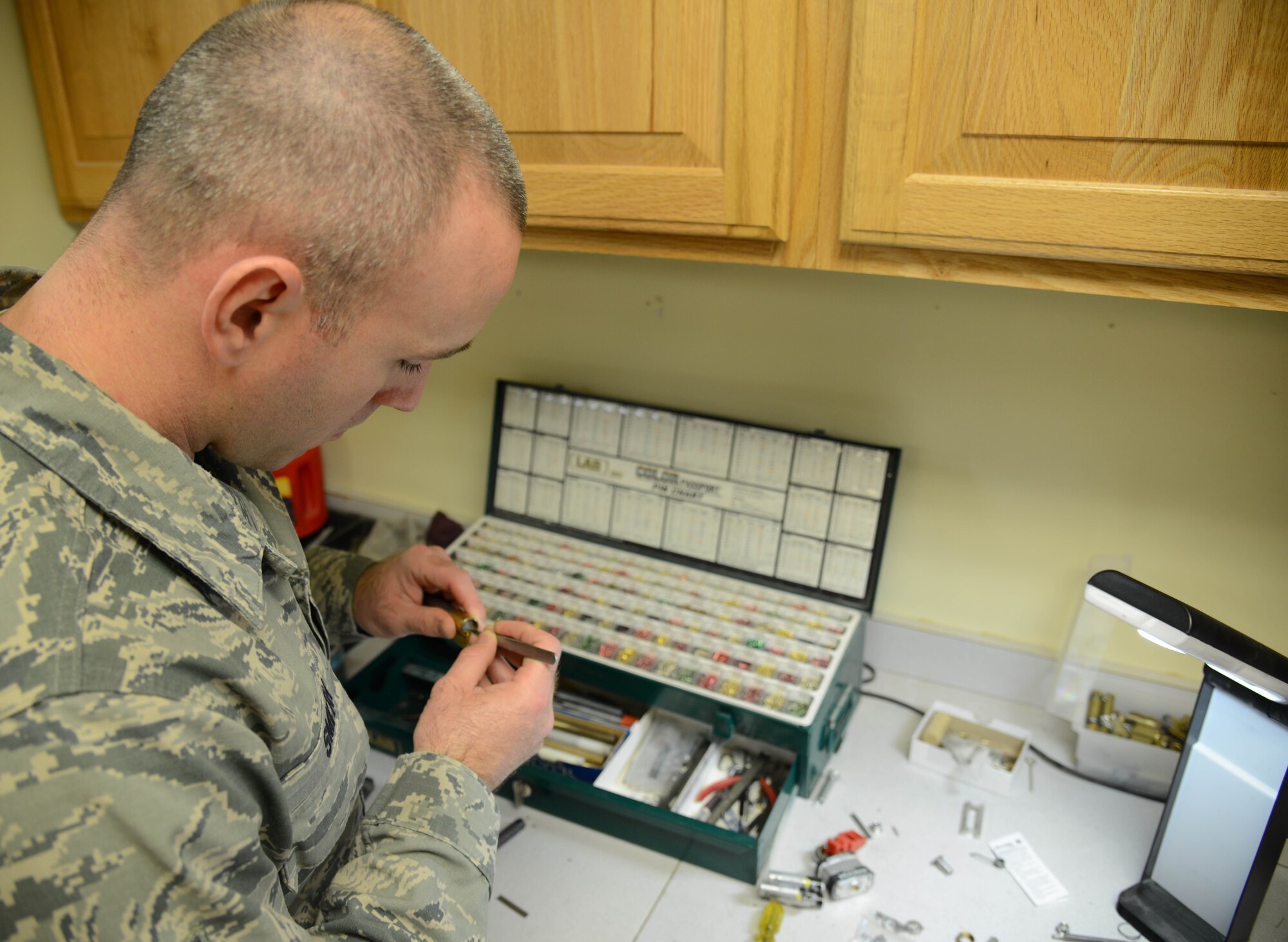 Senior Airman Kenny Smith, 341st Civil Engineer Squadron structural journeyman, disassembles a lock to re-key it Feb. 3, 2015, at Malmstrom Air Force Base, Mont. Re-keying involves stripping a lock down to its bare essentials and replacing the tumblers and springs inside it. (U.S. Air Force photo/Airman 1st Class Dillon Johnston)