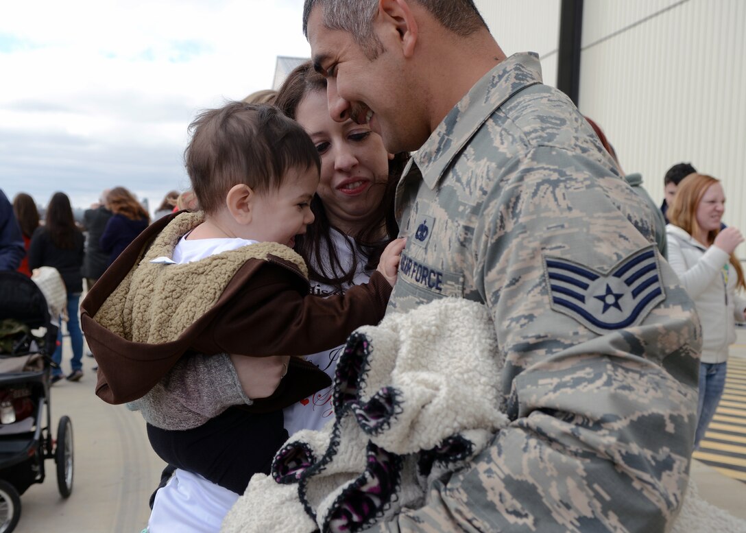 U.S. Air Force Staff Sgt. Alejandro Valencia Hernandez, 7th Aircraft Maintenance Squadron, is welcomed by his wife, Kylie, and son, Josiah, after returning from a six-month deployment Feb. 1, 2015, at Dyess Air Force Base, Texas. While deployed to Al Udeid Air Base, Qatar, Dyess service members provided rapid, long-range precision strike capability and persistent air presence to support military objectives in the region. (U.S. Air Force photo by Airman 1st Class Kedesha Pennant/Released)