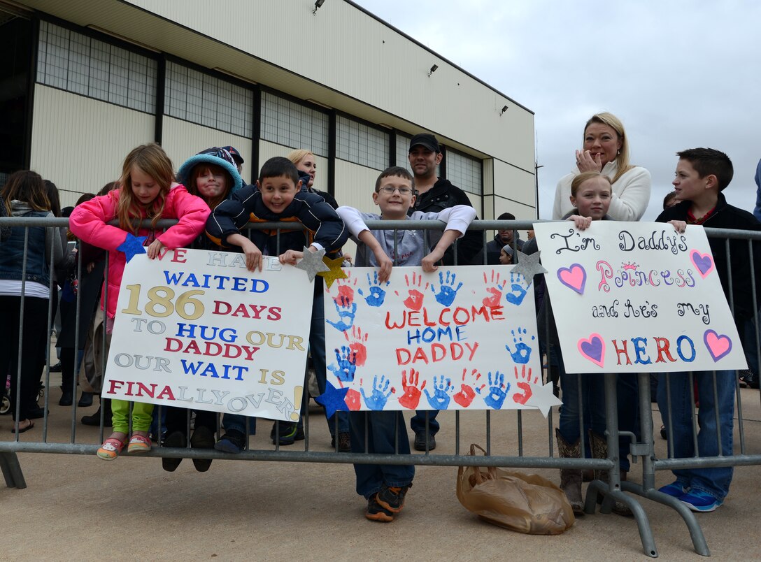 Children of returning service members display homecoming signs Feb. 1, 2015, at Dyess Air Force Base, Texas. Dyess Airmen from the 9th Bomb Squadron, 7th Maintenance Group and 7th Operations Support Squadron returned after a six-month deployment and were greeted by family members and friends. (U.S. Air Force photo by Airman 1st Class Kedesha Pennant/Released)