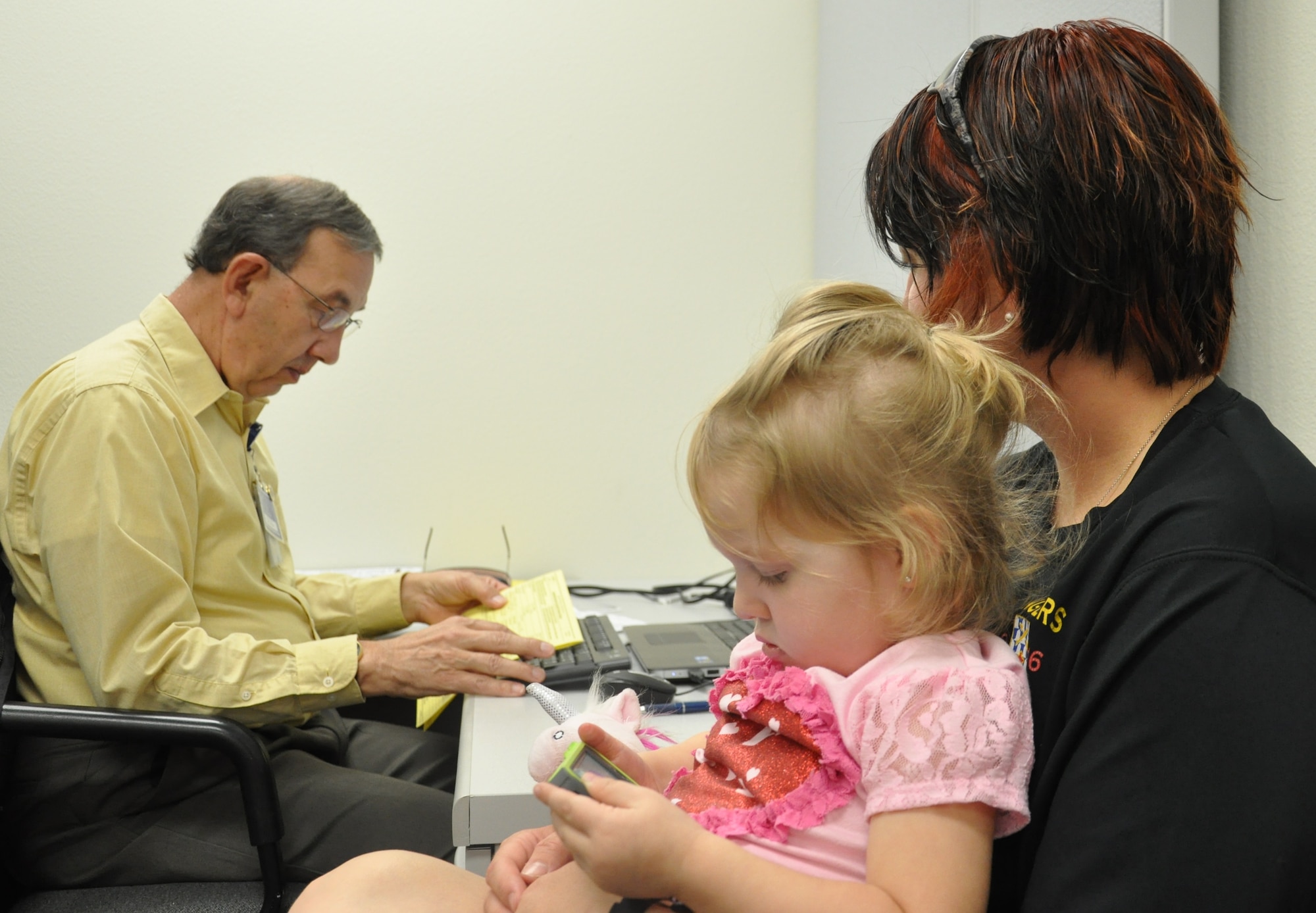 Amanda Behan and her daughter, Izzy, have their taxes prepared by Gary Little, a volunteer income tax preparer at the Volunteer Income Tax Assistance center, located in the Patrick AFB Shark Center. The center is open from 9 a.m. to 5 p.m. Monday through Friday until April 15.  The tax service is free of charge, but a food donation box will be available for people who wish to donate canned or boxed food. The food will be distributed to local area food programs. For more information, or to schedule an appointment, call (321) 494-4718. (U.S. Air Force Photo/Tech. Sgt. Erin Smith)