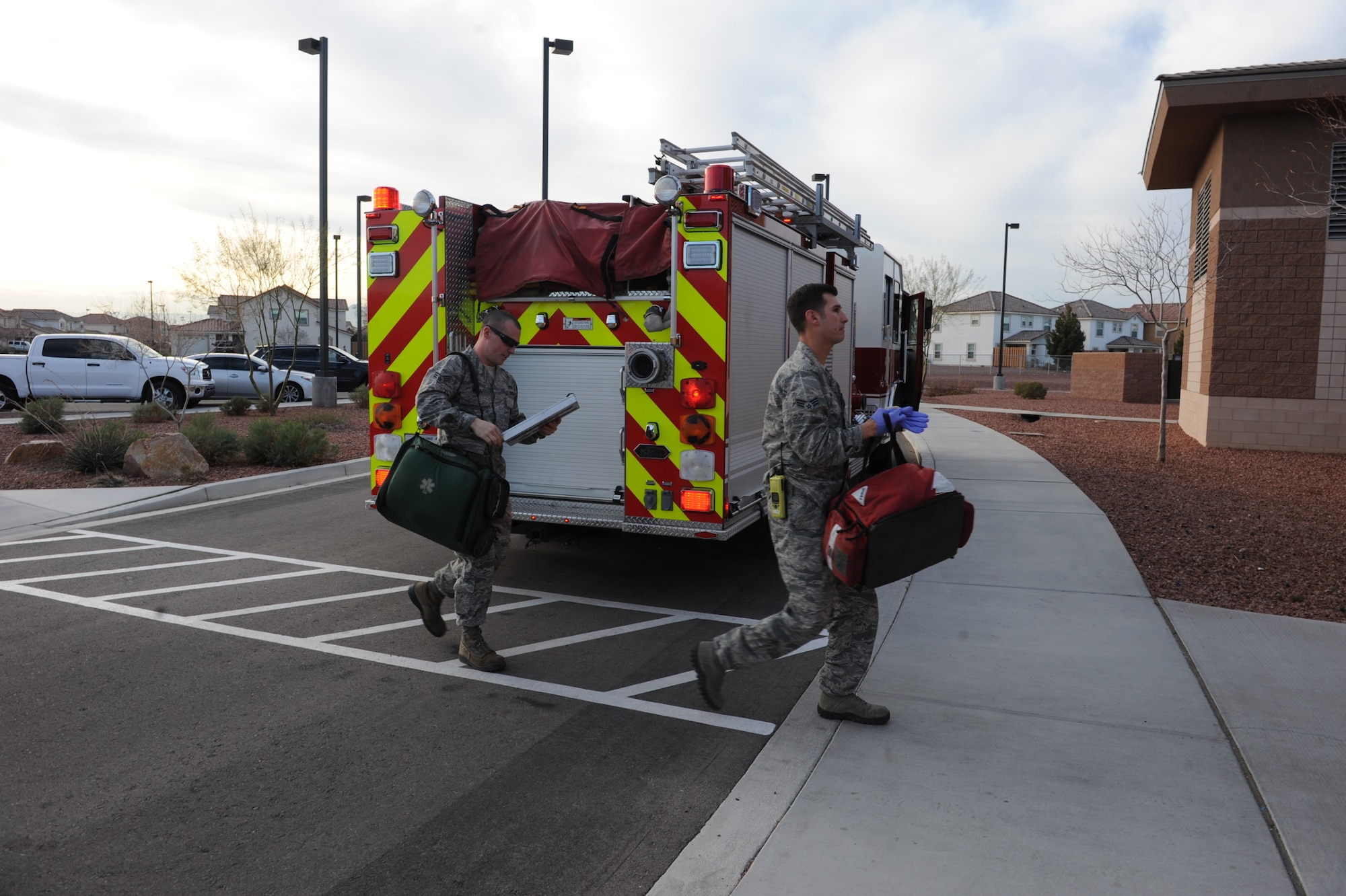 Senior Airmen Cody Malia and Blake Smith, 99th Civil Engineer Squadron fire protection journeymen, respond to a medical emergency at the Child Development Center at Nellis Air Force Base, Nev., Feb. 2, 2015. Fire protection Airmen are all trained emergency medical responders who can provide life-saving treatment until paramedics arrive. (U.S. Air Force photo by Staff Sgt. Victoria Sneed)