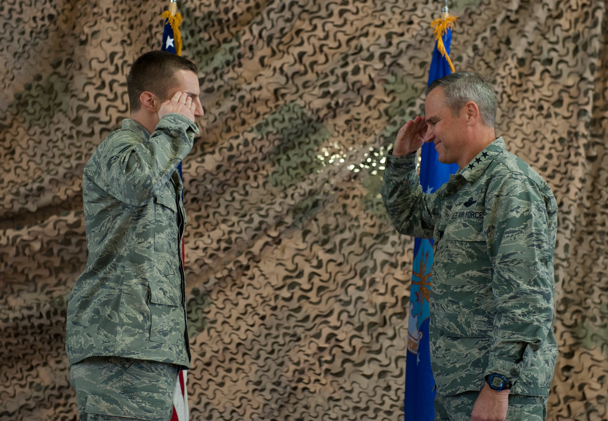 Senior Airman Zachary Nichols, 49th Wing Medical Group medical logistics technician, salutes Lt. Gen. Chris Nowland, 12th Air Force commander, after being coined Feb. 4, 2015 at Holloman Air Force Base, N.M. Nichols was publicly recognized at the base all-call for winning the Air Force Medical Service Medical Materiel Airman of the Year award. (U.S. Air Force photo by Airman 1st Class Emily A. Kenney/Released)