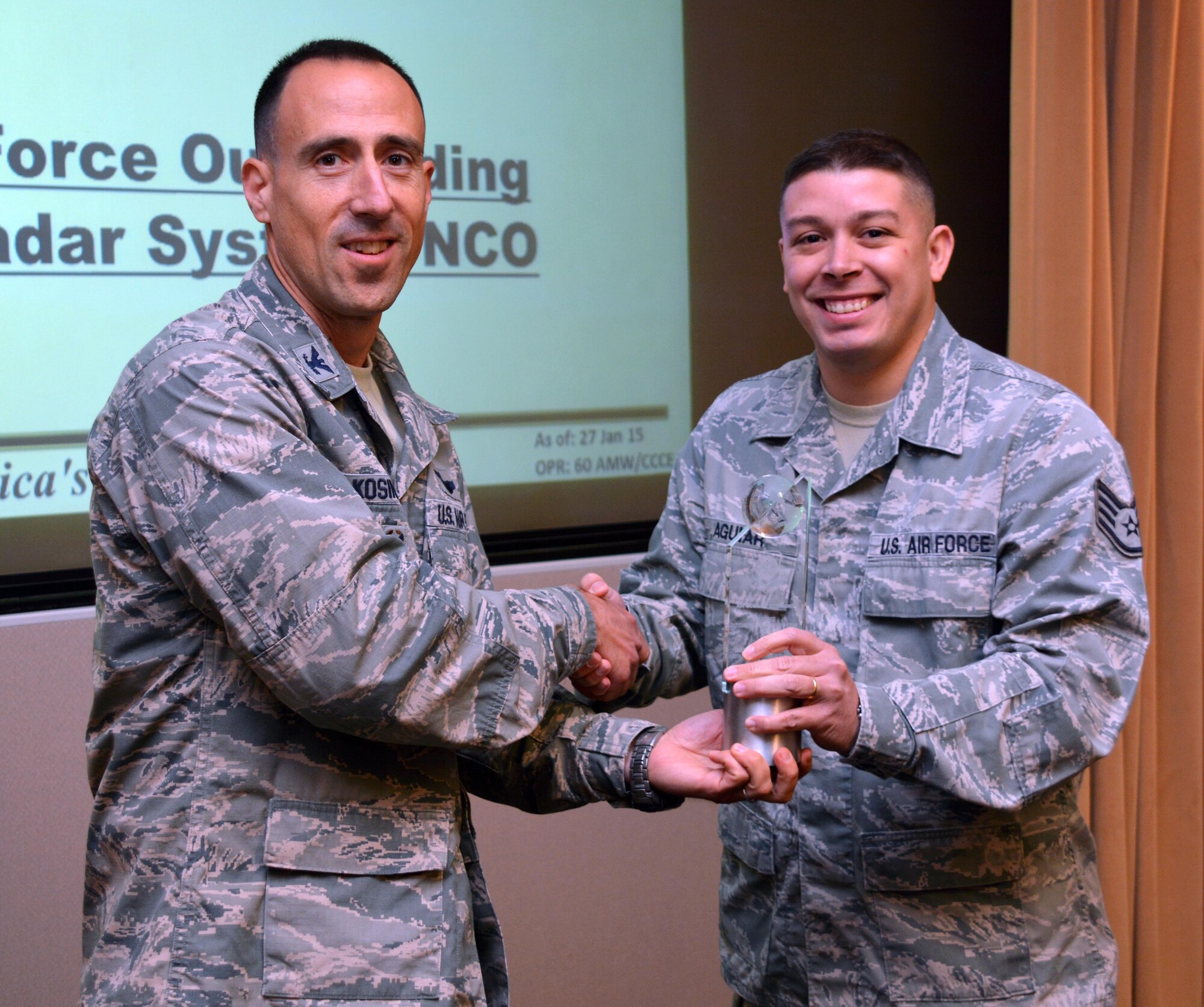 Col. Leonard Kosinski, 60th Air Mobility Wing vice commander, presents Staff Sgt. Jefferson Aguiar, 60th Operations Support Squadron NCO in charge of ground radar systems, an award for being named Air Mobility Command’s Outstanding Ground Radar System NCO of the Year Jan. 28, 2015, at Travis Air Force Base, California. Aguiar has now been awarded the AMC-level award in consecutive years. (U.S. Air Force photo by Senior Airman Charles Rivezzo)  
