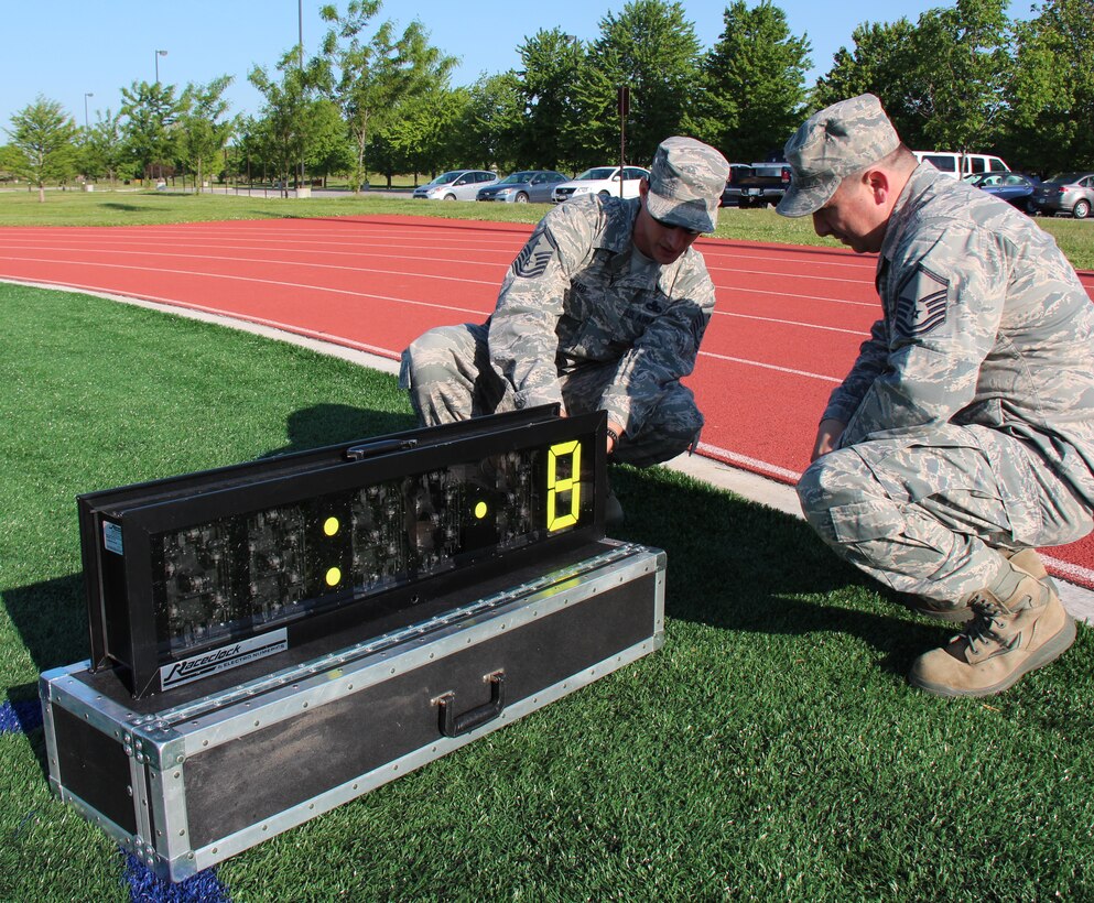 932nd Airlift Wing fitness monitors check the official timer at the base track before a schedule run.  The track now features artificial grass on the infield that can be used year around.  (U.S. Air Force photo/Maj. Stan Paregien)