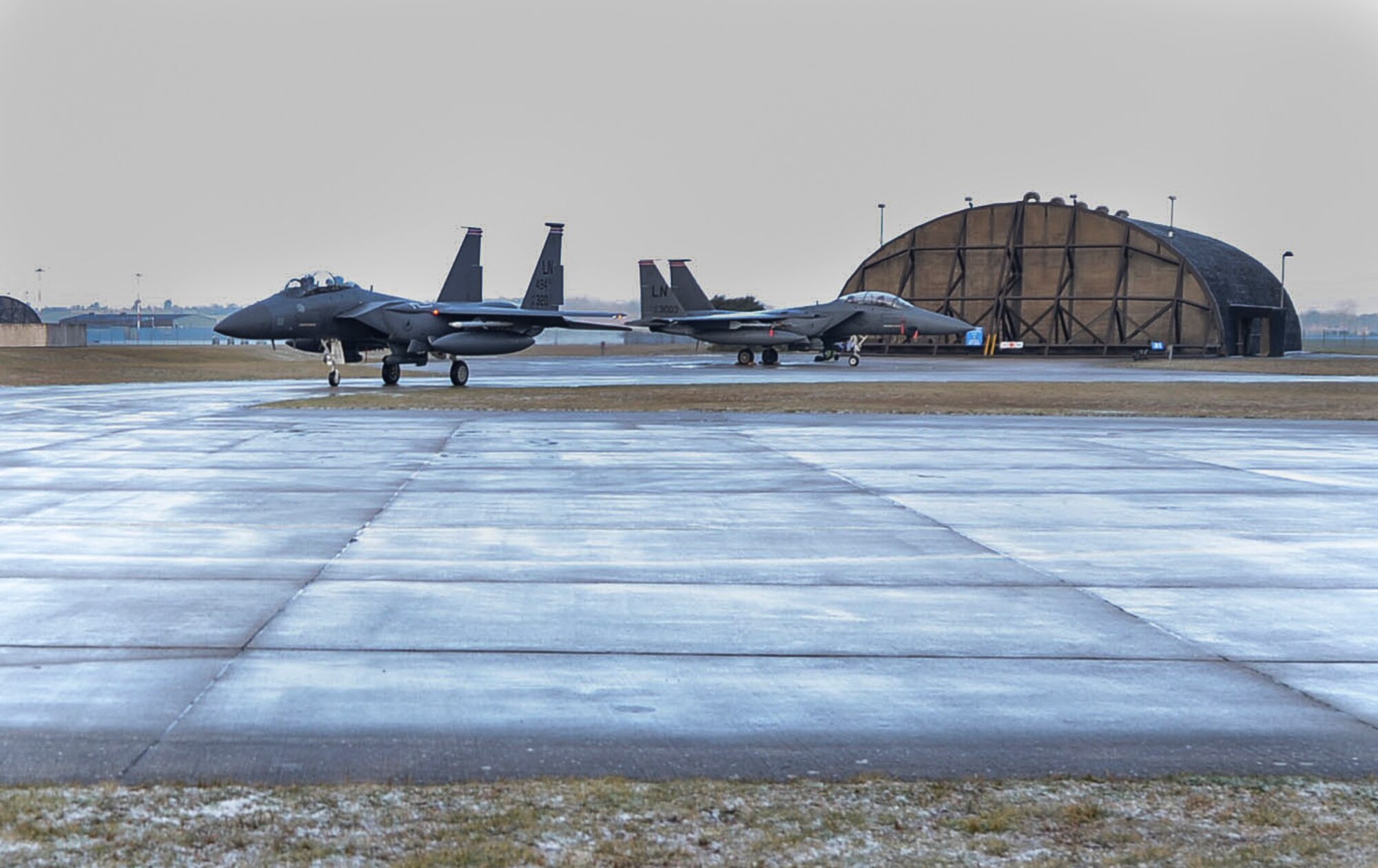 Two F-15E Strike Eagles await instruction from the aircraft control tower before takeoff at Royal Air Force Lakenheath, England, Feb. 4, 2015. The 494th Fighter Squadron participated in a three-day exercise to evaluate their response time to real-world alerts. (U.S. Air Force photo by Airman 1st Class Dawn M. Weber/Released)