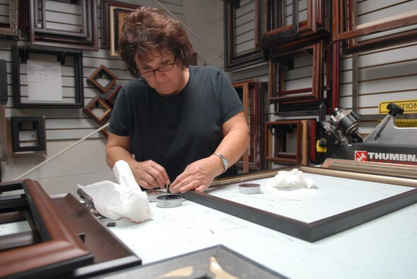 Karen Hamilton, Robins Arts & Crafts Center framer, assembles a custom frame. She fills the wood at the corner joints to make frames join perfectly together.(U.S. Air Force photo by Misuzu Allen)