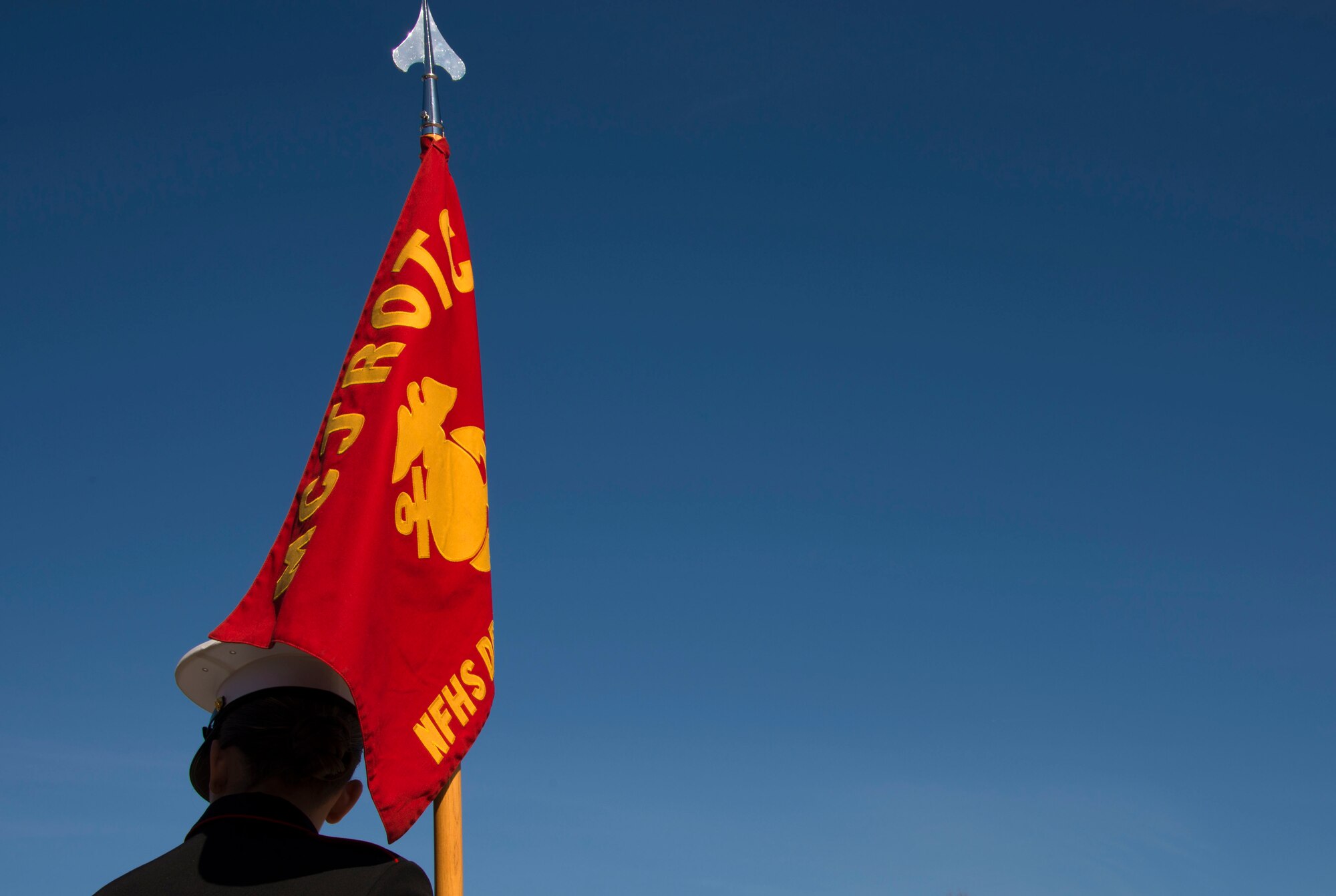 The flag bearer for the North Forsyth High School Marine Corps Junior ROTC unit from Cumming, Georgia, holds the unit’s guidon while waiting to compete during the Larry Jones Invitational Drill Meet hosted by Robert E. Lee High School, Montgomery, Alabama, Jan. 31, 2015. The Marine unit took home the highest honor of the night, the Commander’s Trophy. (U.S. Air Force photo by Airman 1st Class Alexa Culbert/Cleared)